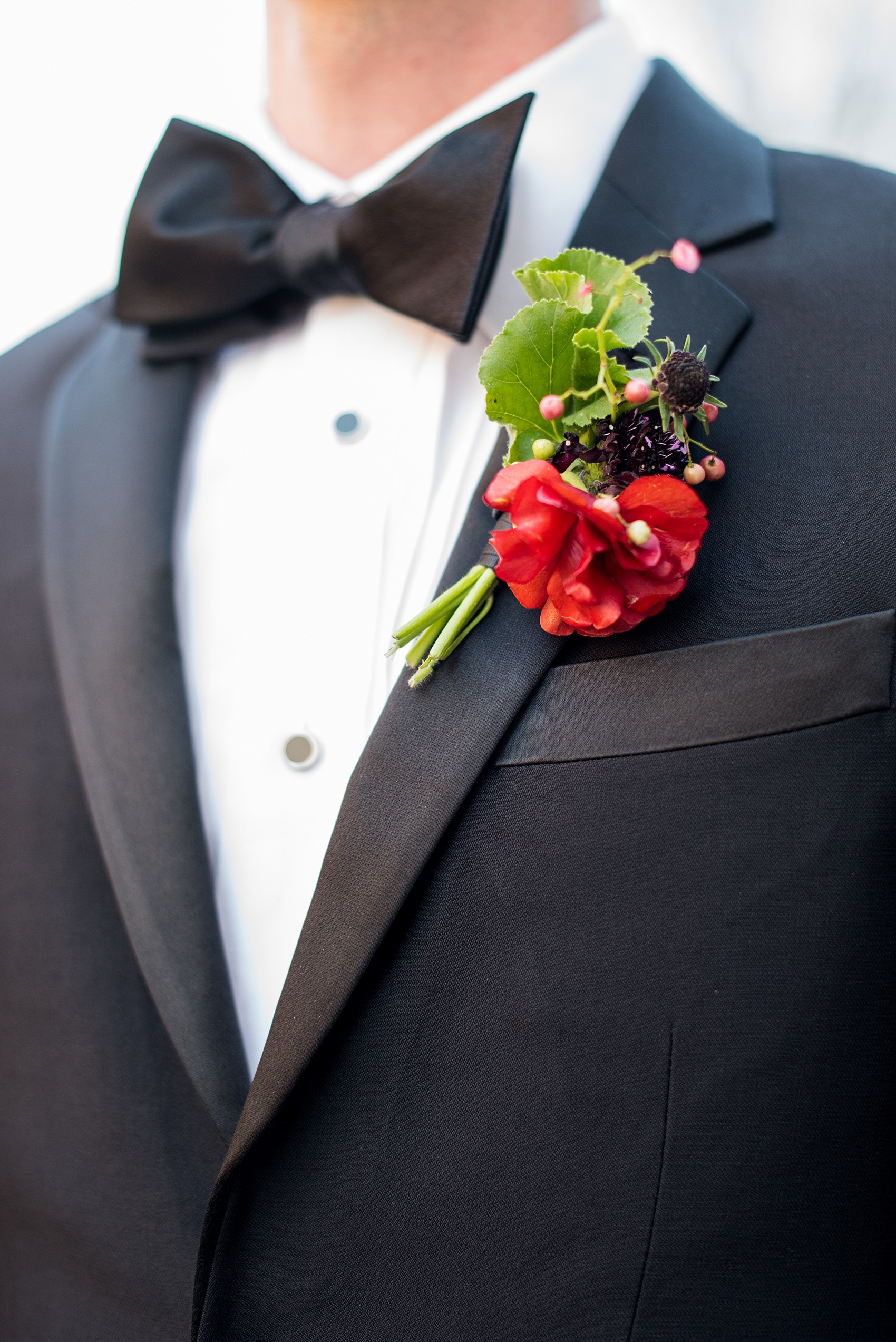 W Hoboken wedding photos by Mikkel Paige Photography. Picture of a deep red/burgundy boutonniere on one of the groomsman by Sachi Rose Designs, including ranunculus, geranium leaves and cosmos. #mikkelpaige #HobokenWedding #NewJerseyPhotographer #NewYorkCityPhotographer #NYCweddingphotographer #brideandgroomphotos #redpeonies #romanticwedding #springwedding #CityWedding