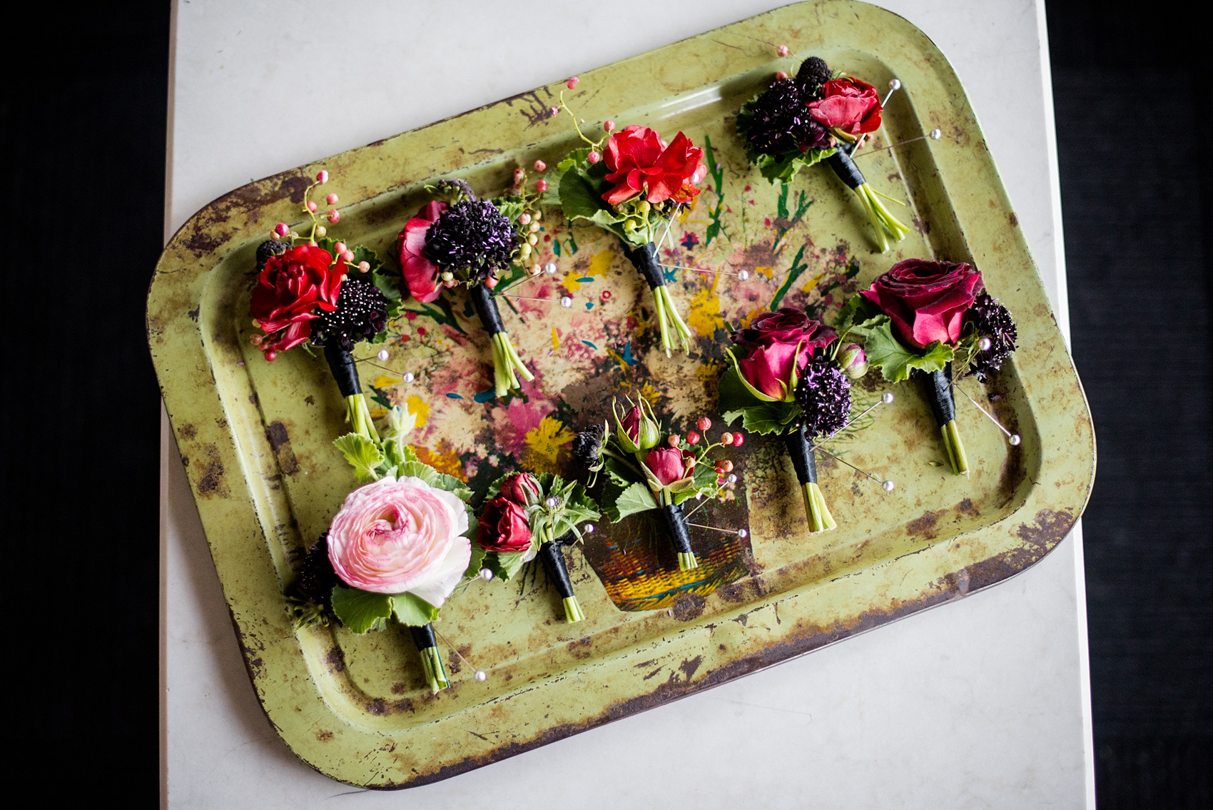 W Hoboken wedding photos by Mikkel Paige Photography. Picture of the varied boutonnieres for the groom and groomsmen by Sachi Rose Designs, including ranunculus, geranium leaves and cosmos. #mikkelpaige #HobokenWedding #NewJerseyPhotographer #NewYorkCityPhotographer #NYCweddingphotographer #brideandgroomphotos #redpeonies #romanticwedding #springwedding #CityWedding