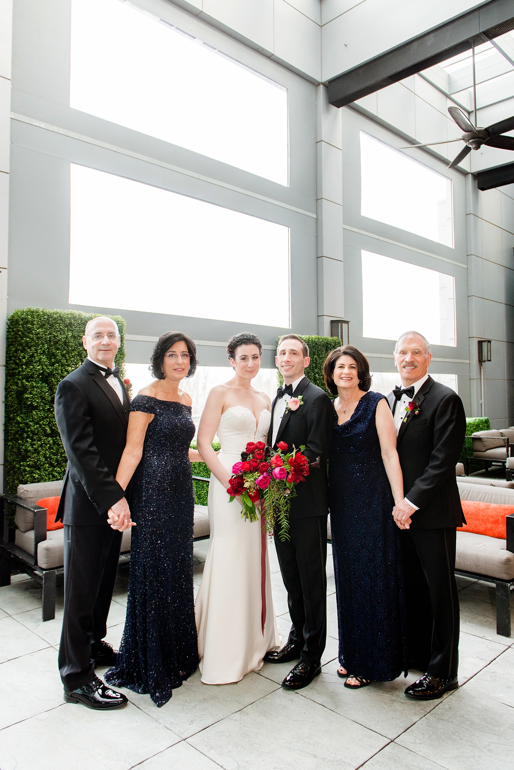 W Hoboken wedding photos by Mikkel Paige Photography at this New Jersey venue close to NYC. Family picture taken during the bride and groom's wedding day with both sets of parents. #mikkelpaige #HobokenWedding #NewJerseyPhotographer #NewYorkCityPhotographer #NYCweddingphotographer #brideandgroomphotos #redpeonies #romanticwedding #springwedding #CityWedding