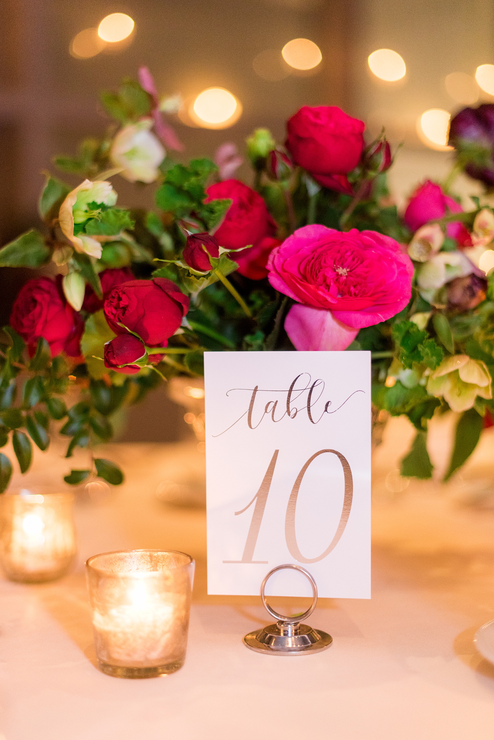 W Hoboken wedding photos at this New Jersey hotel overlooking the NYC skyline. Photos by Mikkel Paige Photography of the table number in gold script for a romantic candlelit reception. #mikkelpaige #HobokenWedding #NewJerseyPhotographer #NewYorkCityPhotographer #NYCweddingphotographer #brideandgroomphotos #redpeonies #romanticwedding #springwedding #CityWedding