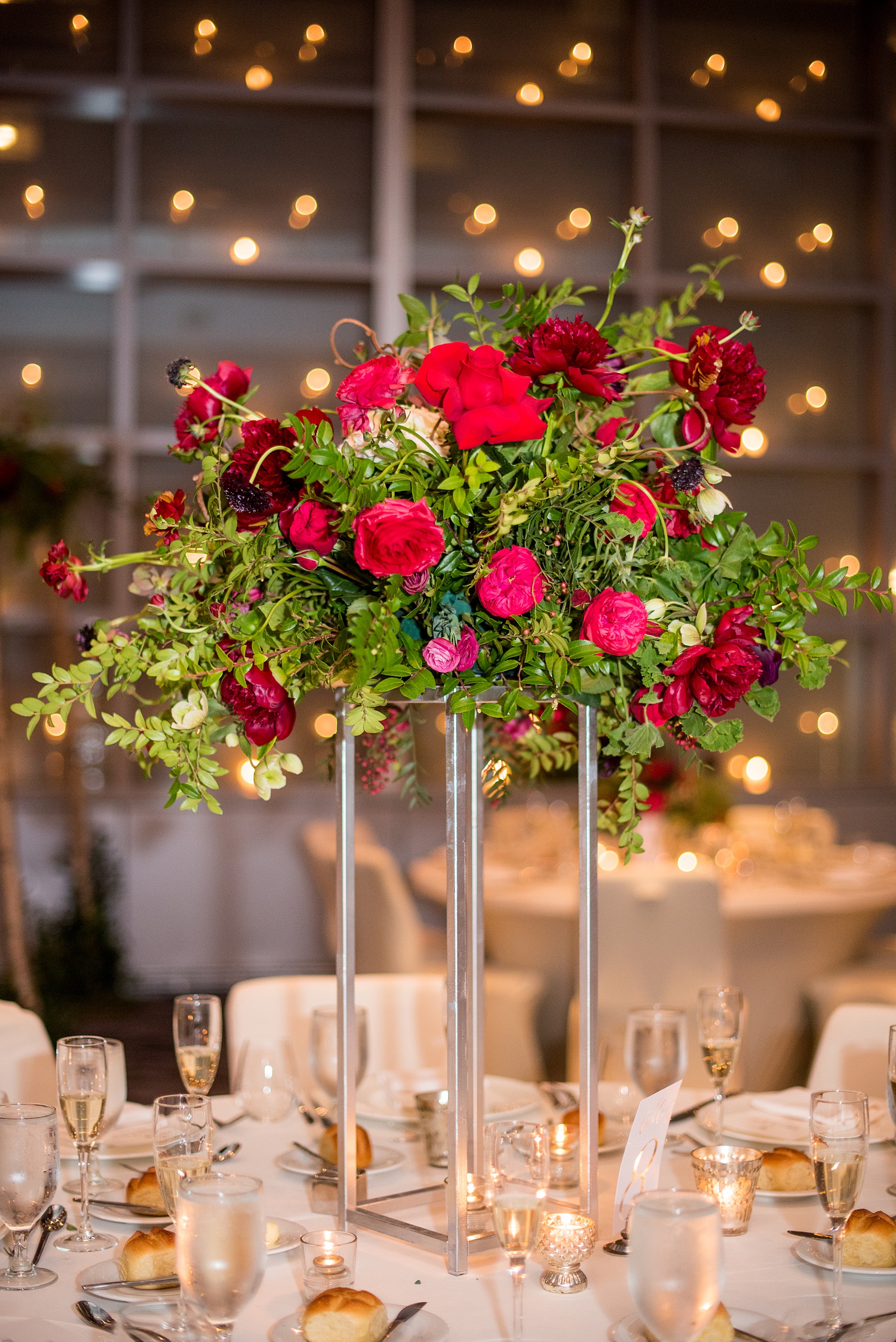 W Hoboken wedding photos at this New Jersey hotel overlooking the NYC skyline. Photos by Mikkel Paige Photography of the elevated, tall reception centerpiece with foxglove, burgundy calla lilies, roses, red peonies, and pink ranunculus by Sachi Rose Design. #mikkelpaige #HobokenWedding #NewJerseyPhotographer #NewYorkCityPhotographer #NYCweddingphotographer #brideandgroomphotos #redpeonies #romanticwedding #springwedding #CityWedding