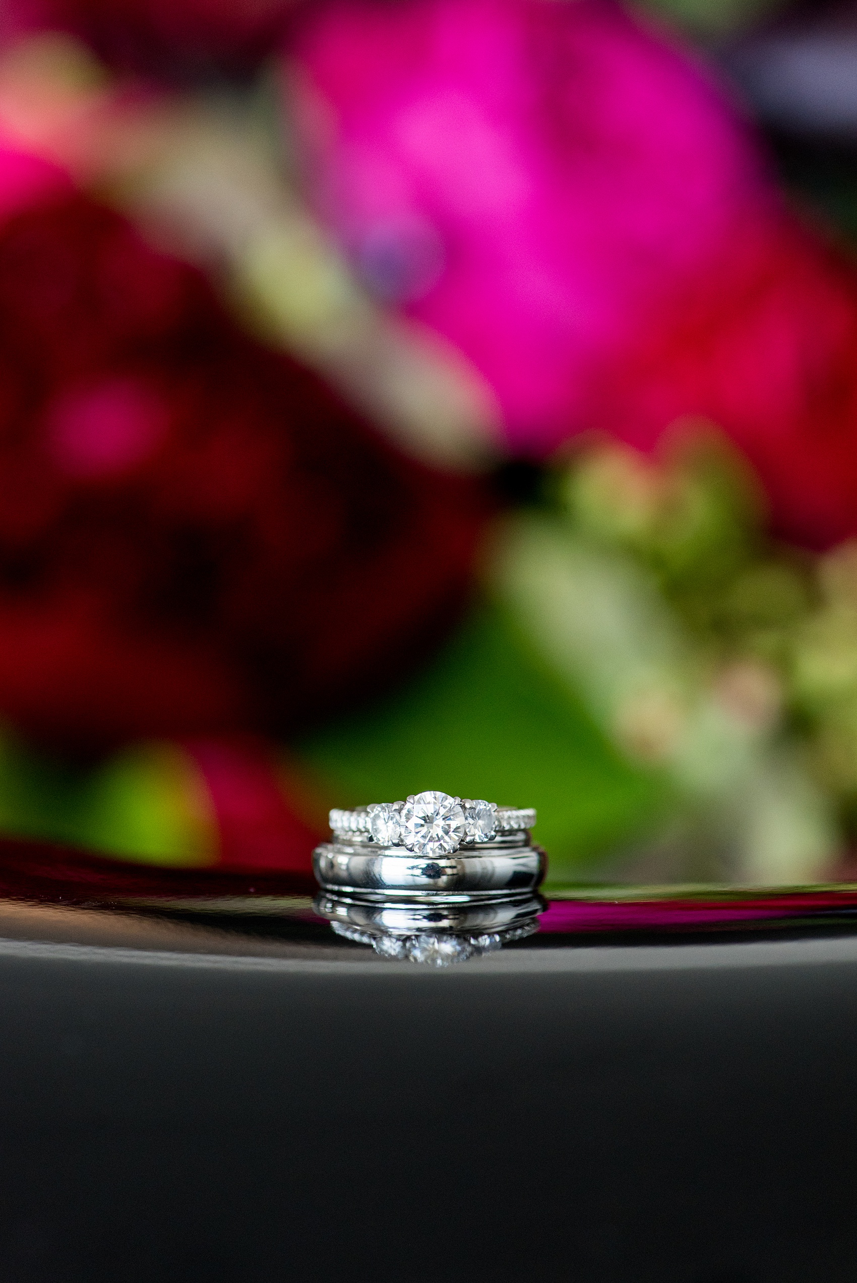 W Hoboken Wedding Photos by Mikkel Paige Photography. Spring wedding overlooking the NYC skyline, with a sexy black, deep red, burgundy and fuchsia color palette. Detail picture of the white gold diamond rings. #HobokenWedding #mikkelpaige #springwedding #romanticwedding #NewJerseyWeddingPhotos