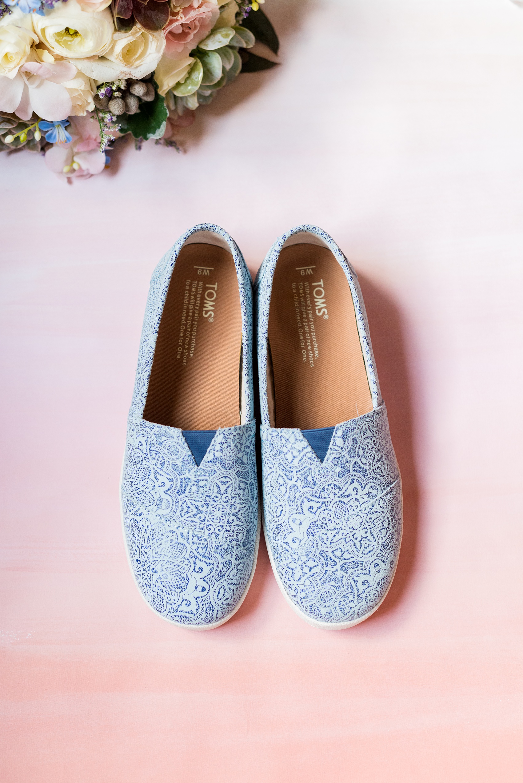 Crystal Springs Resort wedding photos in New Jersey, with photographer Mikkel Paige Photography. The couple’s spring wedding had an outdoor ceremony with photos at this rustic, woodsy venue showing their blue and pink palette decor from getting ready to their reception. This detail picture shows the bride's blue lace pattern Toms she wore to stay comfortable in flat shoes the entire day. Click through to see their complete wedding recap! #NewJerseywedding #MikkelPaige #NJweddingphotographer #NJphotographer #TOMS #TOMSbride #TOMSshoes #TOMSwedding