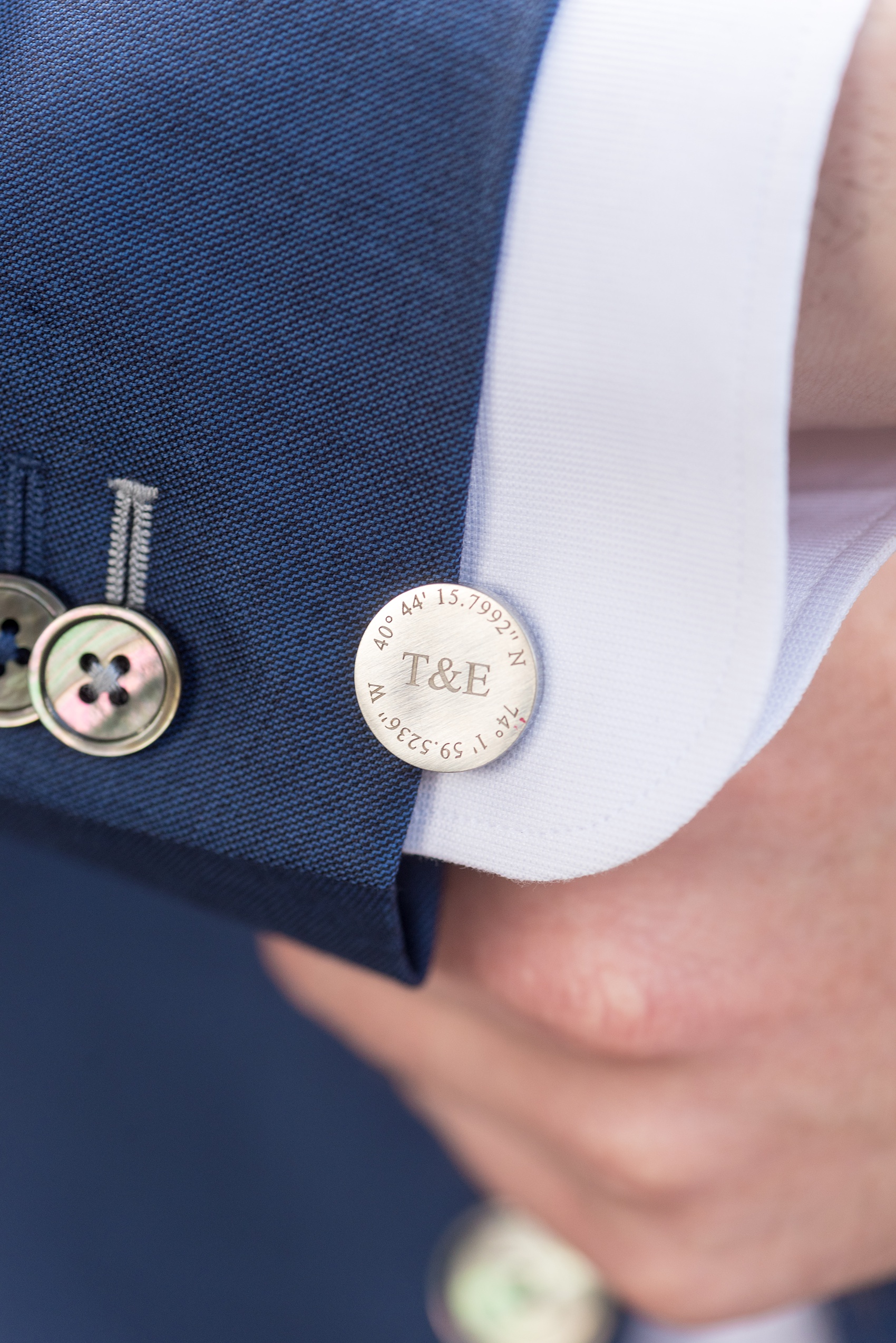 Crystal Springs Resort wedding photos in New Jersey, with photographer Mikkel Paige Photography. The couple’s spring wedding had an outdoor ceremony with photos at this rustic, woodsy venue showing their blue and pink palette decor from getting ready to their reception. This picture shows the groom's custom cufflink details his bride gifted him - the latitude and longitude coordinates of the place they met and their wedding location. Click through to see their complete wedding recap! #NewJerseywedding #MikkelPaige #NJweddingphotographer #NJphotographer #customcufflinks #groom #weddingdetails