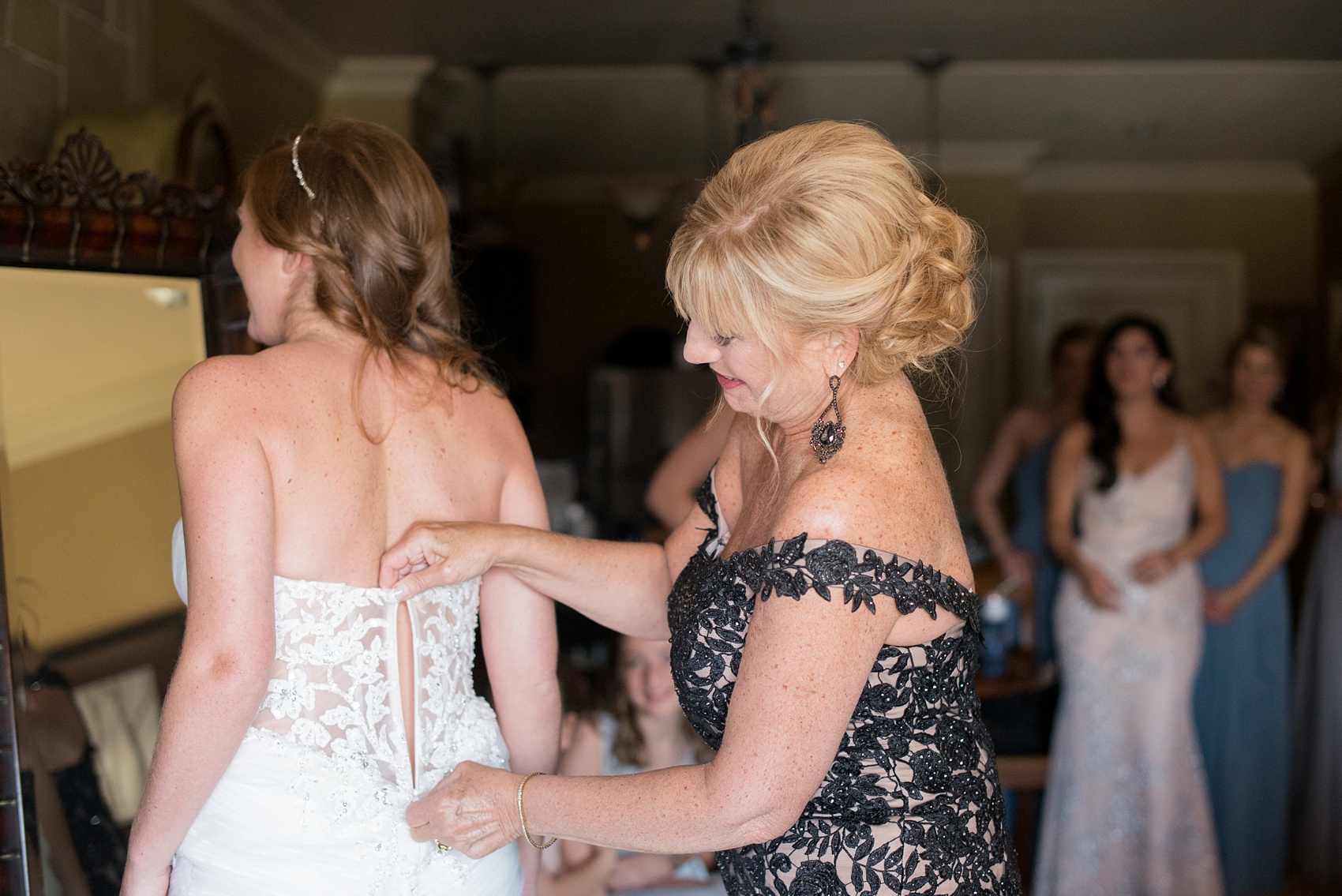 Crystal Springs Resort wedding photos in New Jersey, with photographer Mikkel Paige Photography. The couple’s spring wedding had an outdoor ceremony with photos at this rustic, woodsy venue showing their blue and pink palette decor from getting ready to their reception. This picture shows the bride's mother helping her put her lace gown on. Click through to see their complete wedding recap! #NewJerseywedding #MikkelPaige #NJweddingphotographer #NJphotographer #weddinggown #lacegown #weddingdress #gettingready