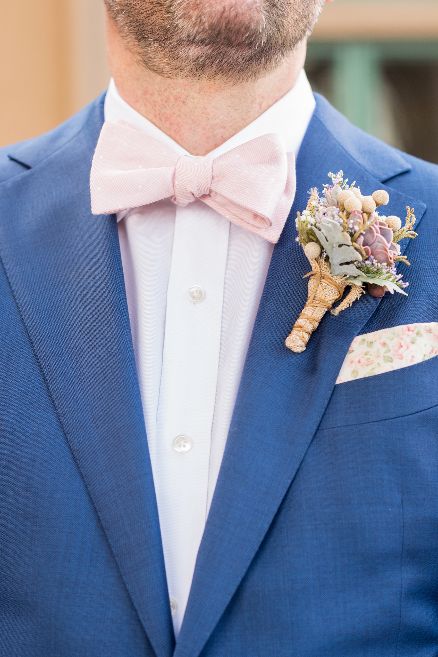 Crystal Springs Resort wedding photos in New Jersey, with photographer Mikkel Paige Photography. The couple’s spring wedding had an outdoor ceremony with photos at this rustic, woodsy venue showing their blue and pink palette decor from getting ready to their reception. This picture shows the groom in his custom navy blue suit with a succulent boutonniere. Click through to see their complete wedding recap! #NewJerseywedding #MikkelPaige #NJweddingphotographer #NJphotographer #customsuit #groom #weddingdetails #pinkbowtie
