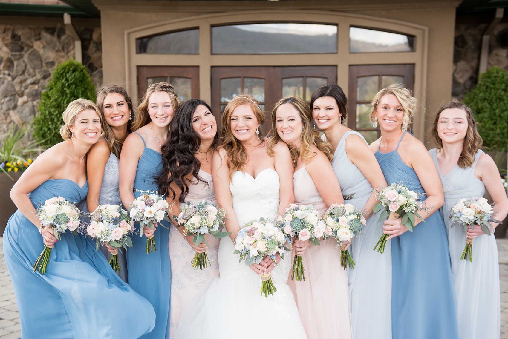 Crystal Springs Resort wedding photos in New Jersey, with photographer Mikkel Paige Photography. The couple’s spring wedding had an outdoor ceremony with photos at this rustic, woodsy venue showing their blue and pink palette decor from getting ready to their reception. This picture shows the bridal party (bridesmaids) in their mismatched blue and pink gowns. Click through to see their complete wedding recap! #NewJerseywedding #MikkelPaige #NJweddingphotographer #NJphotographer #brideandgroom #springwedding #mismatchedgowns #pinkandblue #weddingparty #bridalparty