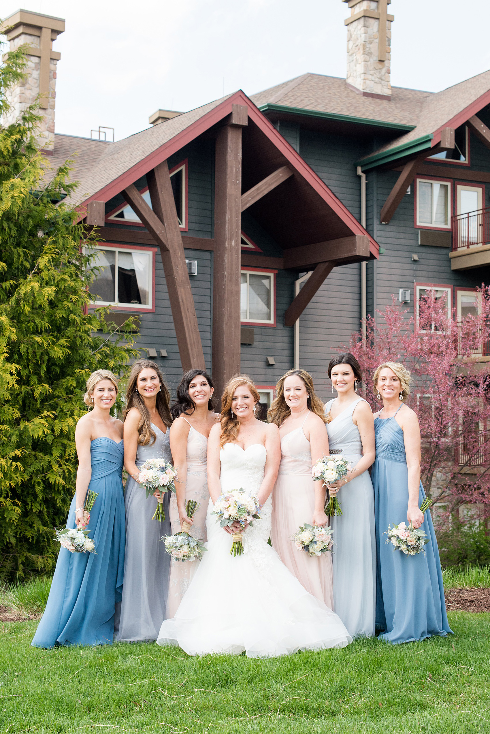 Crystal Springs Resort wedding photos in New Jersey, with photographer Mikkel Paige Photography. The couple’s spring wedding had an outdoor ceremony with photos at this rustic, woodsy venue showing their blue and pink palette decor from getting ready to their reception. This picture shows the bridal party (bridesmaids) in their mismatched blue and pink gowns. Click through to see their complete wedding recap! #NewJerseywedding #MikkelPaige #NJweddingphotographer #NJphotographer #brideandgroom #springwedding #mismatchedgowns #pinkandblue #weddingparty #bridalparty