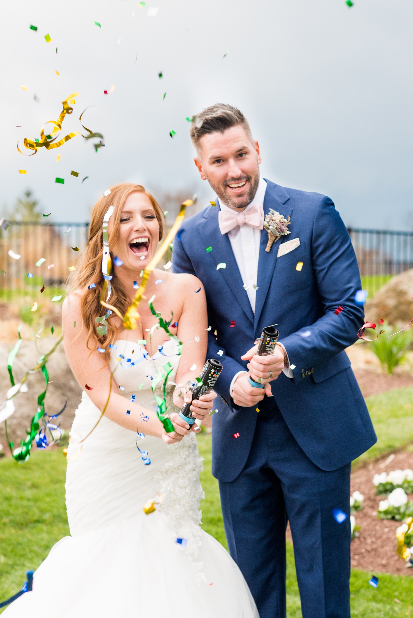 Crystal Springs Resort wedding photos in New Jersey, with photographer Mikkel Paige Photography. The couple’s spring wedding had an outdoor ceremony with photos at this rustic, woodsy venue showing their blue and pink palette decor from getting ready to their reception. This picture shows the bride and groom popping confetti to celebrate the day! Click through to see their complete wedding recap! #NewJerseywedding #MikkelPaige #NJweddingphotographer #NJphotographer #brideandgroom #springwedding #mismatchedgowns #pinkandblue #confettiphotos #confettipoppers #confettiweddingphotos #confettipictures