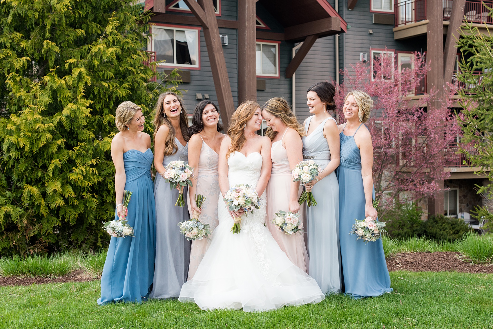 Crystal Springs Resort wedding photos in New Jersey, with photographer Mikkel Paige Photography. The couple’s spring wedding had an outdoor ceremony with photos at this rustic, woodsy venue showing their blue and pink palette decor from getting ready to their reception. This picture shows the bridal party (bridesmaids) in their mismatched blue and pink gowns. Click through to see their complete wedding recap! #NewJerseywedding #MikkelPaige #NJweddingphotographer #NJphotographer #brideandgroom #springwedding #mismatchedgowns #pinkandblue #weddingparty #bridalparty