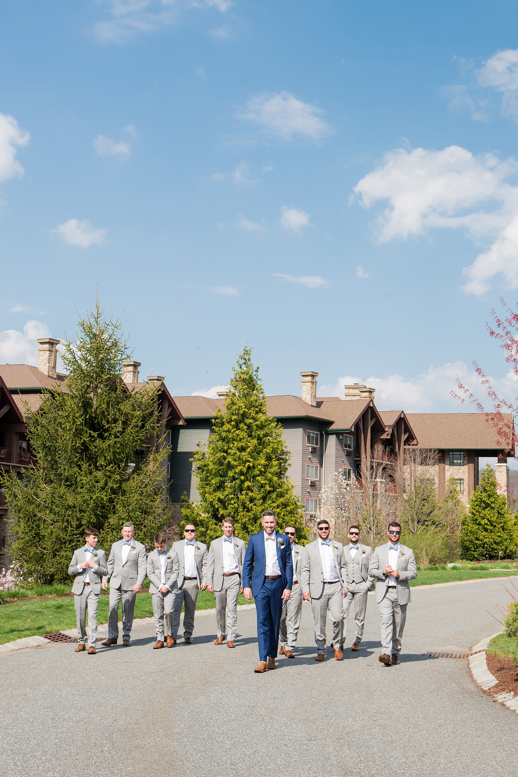 Crystal Springs Resort wedding photos in New Jersey, with photographer Mikkel Paige Photography. The couple’s spring wedding had an outdoor ceremony with photos at this rustic, woodsy venue showing their blue and pink palette decor from getting ready to their reception. This picture shows the groomsmen in their grey suits and blue bow ties with the groom in a custom navy suit and pink bow tie. Click through to see their complete wedding recap! #NewJerseywedding #MikkelPaige #NJweddingphotographer #NJphotographer #brideandgroom #springwedding #pinkandblue #weddingparty #groomsmen #bowties