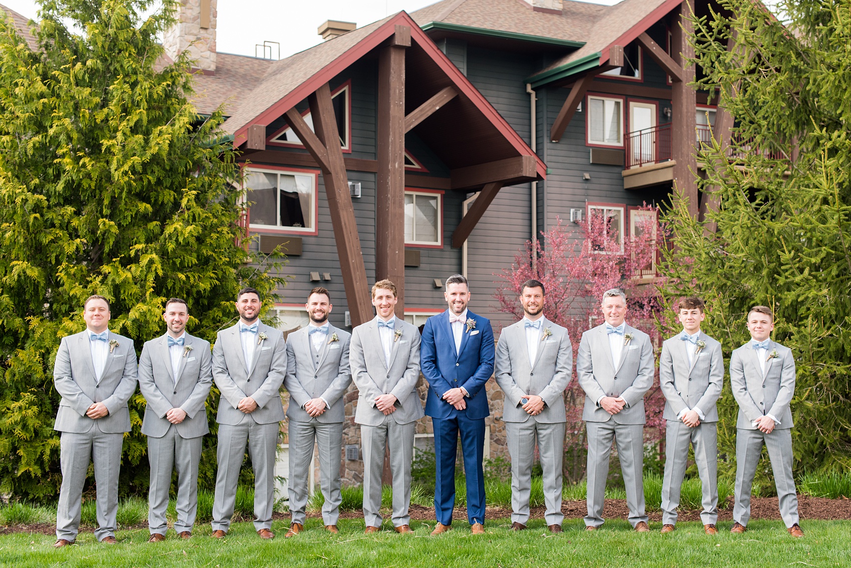 Crystal Springs Resort wedding photos in New Jersey, with photographer Mikkel Paige Photography. The couple’s spring wedding had an outdoor ceremony with photos at this rustic, woodsy venue showing their blue and pink palette decor from getting ready to their reception. This picture shows the groomsmen in their grey suits and blue bow ties with the groom in a custom navy suit and pink bow tie. Click through to see their complete wedding recap! #NewJerseywedding #MikkelPaige #NJweddingphotographer #NJphotographer #brideandgroom #springwedding #pinkandblue #weddingparty #groomsmen #bowties