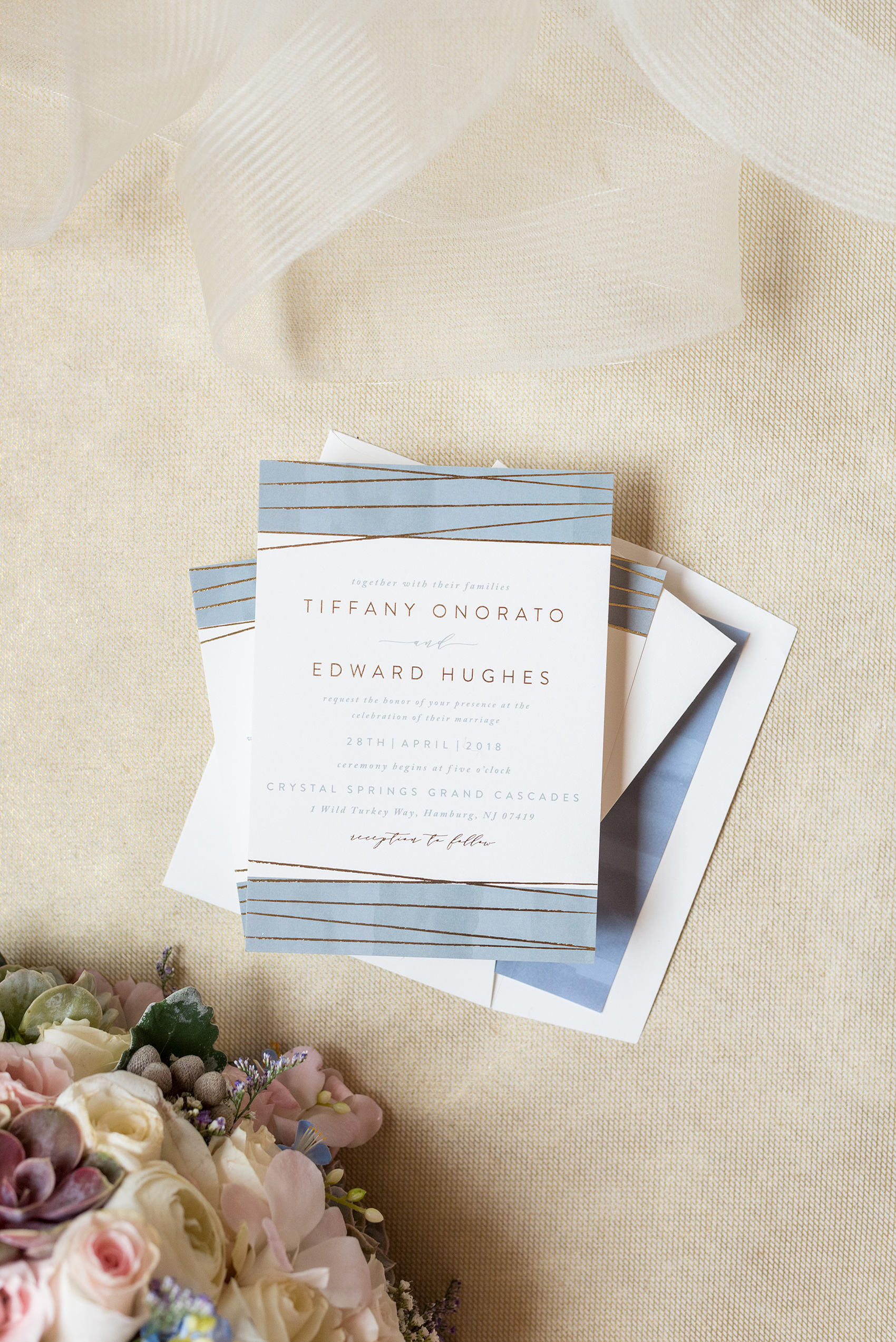 Crystal Springs Resort wedding photos in New Jersey, with photographer Mikkel Paige Photography. The couple’s spring wedding had an outdoor ceremony with photos at this rustic, woodsy venue showing their blue and pink palette decor from getting ready to their reception. This detail picture shows the couple's gold and blue wedding invitation. Click through to see their complete wedding recap! #NewJerseywedding #MikkelPaige #NJweddingphotographer #NJphotographer #springwedding #pinkandblue #weddinginvitation