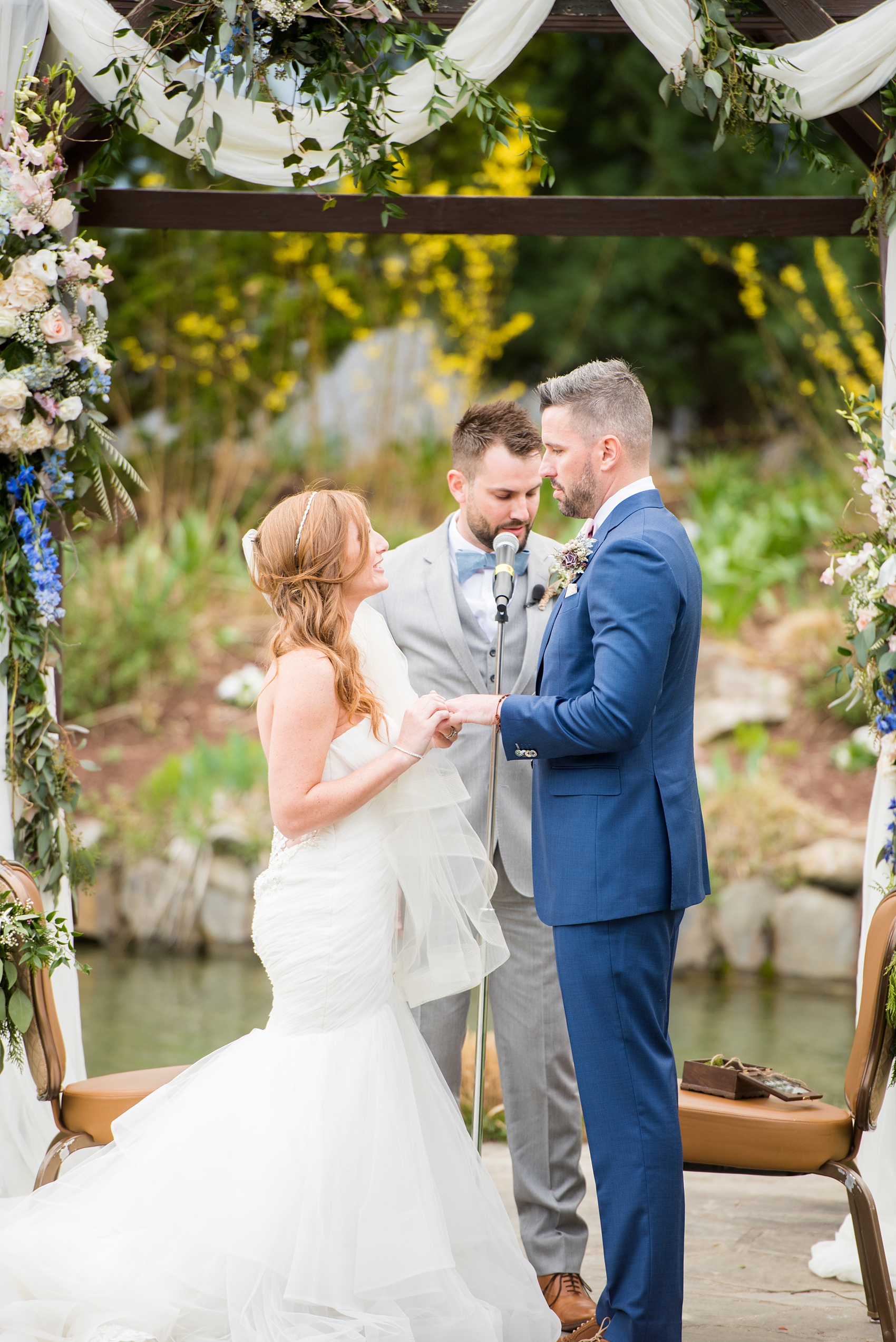 Crystal Springs Resort wedding photos in New Jersey, with photographer Mikkel Paige Photography. The couple’s spring wedding had an outdoor ceremony with photos at this rustic, woodsy venue showing their blue and pink palette decor from getting ready to their reception. This photo shows the bride and groom reciting vows. Click through to see their complete wedding recap! #NewJerseywedding #MikkelPaige #NJweddingphotographer #NJphotographer #springwedding #pinkandblue #outdoorceremony #weddingvows