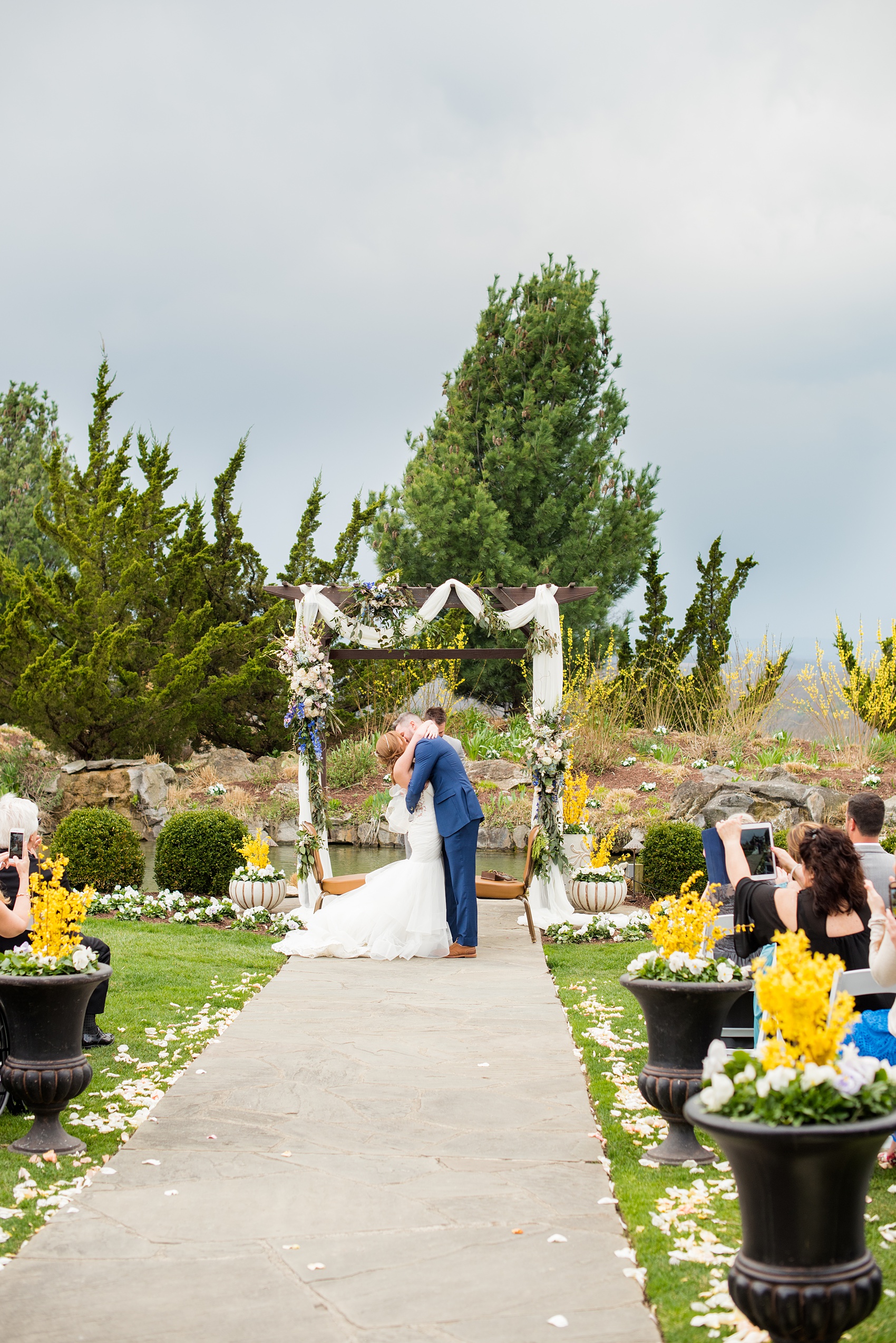 Crystal Springs Resort wedding photos in New Jersey, with photographer Mikkel Paige Photography. The couple’s spring wedding had an outdoor ceremony with photos at this rustic, woodsy venue showing their blue and pink palette decor from getting ready to their reception. This photo shows the bride and groom's first kiss as a married couple. Click through to see their complete wedding recap! #NewJerseywedding #MikkelPaige #NJweddingphotographer #NJphotographer #springwedding #pinkandblue #outdoorceremony #weddingkiss #firstkiss