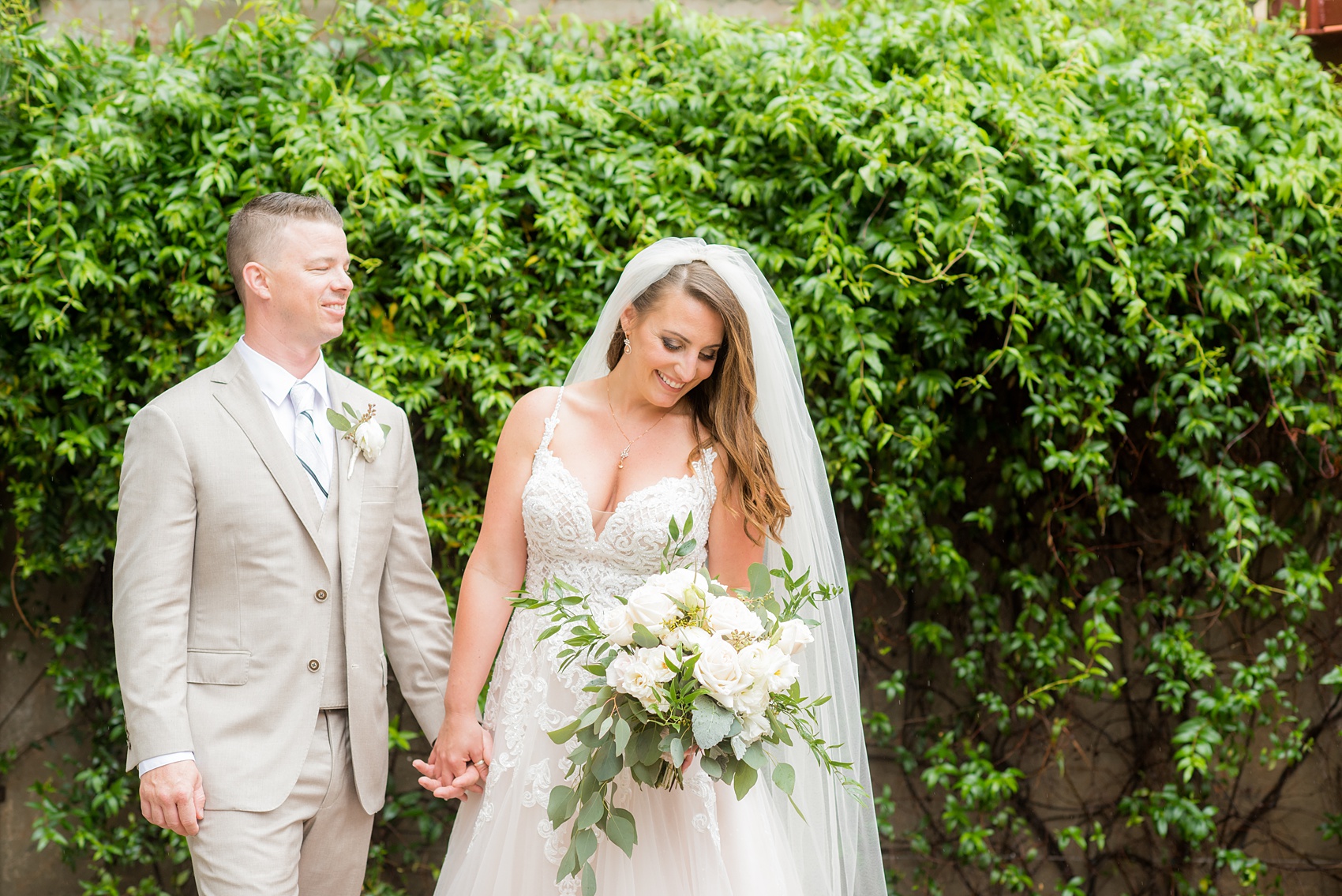 The Rickhouse wedding photos by Mikkel Paige photography in Durham, North Carolina. This urban venue has all the charm of the south for this bride and groom's spring wedding! This picture shows the bride and groom at American Tobacco Campus against a gorgeous wall of green ivy. Click to see more from their day! #mikkelpaige #northcarolina #southernwedding #TheRickhouseDurham #rosegoldandpink #brideandgroom