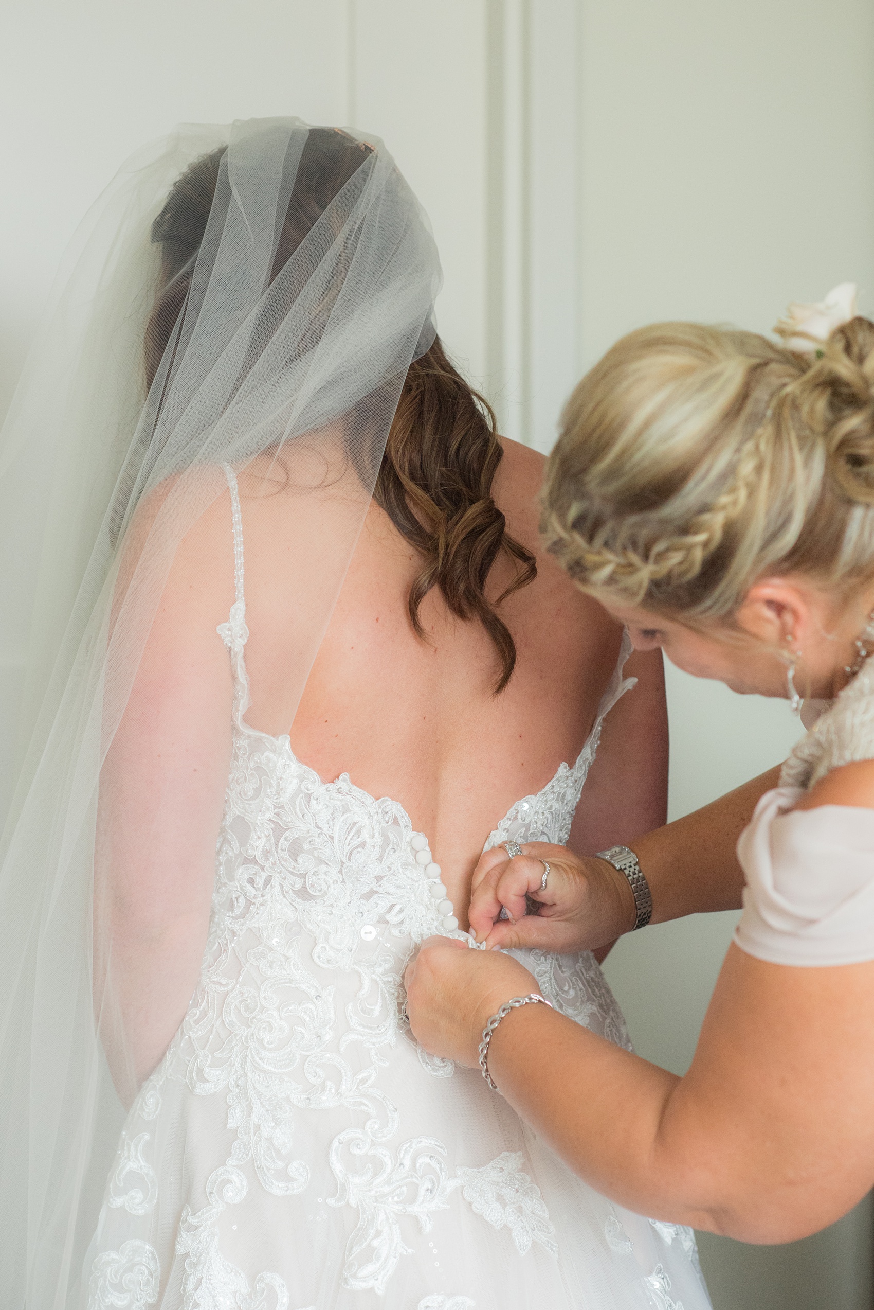 The Rickhouse wedding photos by Mikkel Paige photography in Durham, North Carolina. This urban venue has all the charm of the south for this bride and groom's spring wedding! This picture shows the mother of the bride helping her daughter get into her Essense of Australia wedding gown on her day! Click through to see the complete post! #mikkelpaige #northcarolina #southernwedding #TheRickhouseDurham #rosegoldandpink