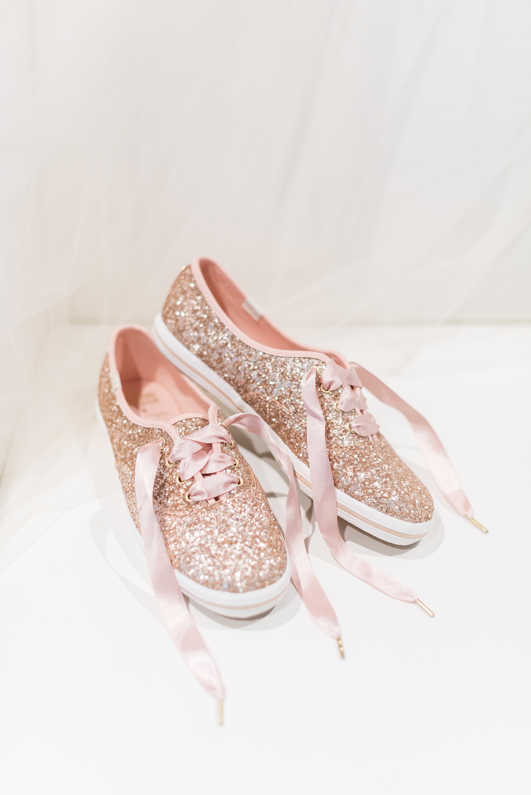 The Rickhouse wedding photos by Mikkel Paige photography in Durham, North Carolina. This urban venue has all the charm of the south for this bride and groom's spring wedding! This detail picture shows the bride's rose gold glitter keds for her reception shoes. Click through to see the complete post! #mikkelpaige #northcarolina #southernwedding #TheRickhouseDurham #rosegoldandpink #glitterkeds #Keds #weddingshoes