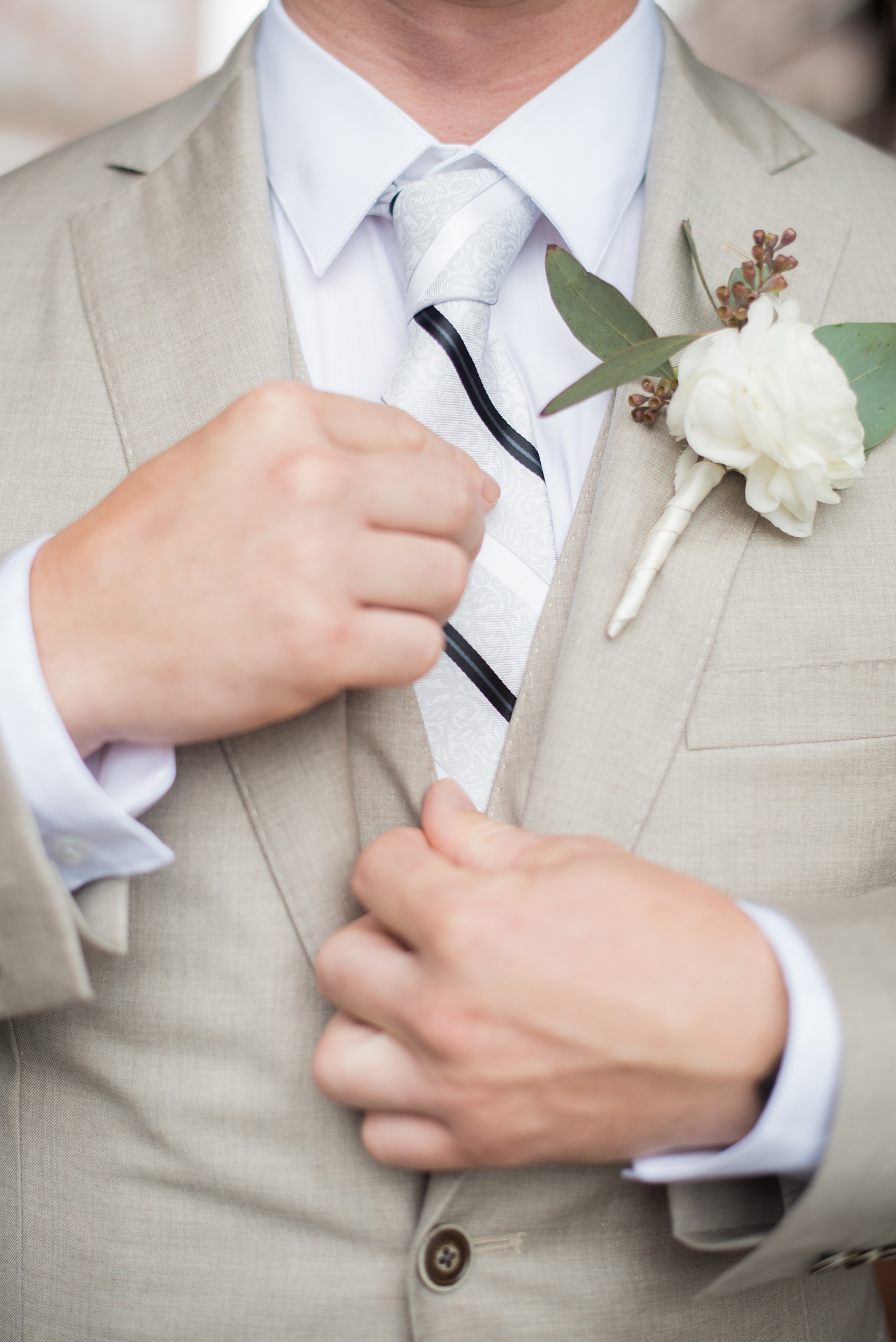 The Rickhouse wedding photos by Mikkel Paige photography in Durham, North Carolina. This urban venue has all the charm of the south for this bride and groom's spring wedding! This detail picture shows the groom's white ranunculus boutonniere with eucalyptus filler. Click through to see the complete post! #mikkelpaige #northcarolina #southernwedding #TheRickhouseDurham #rosegoldandpink #boutonniere #ranunculus