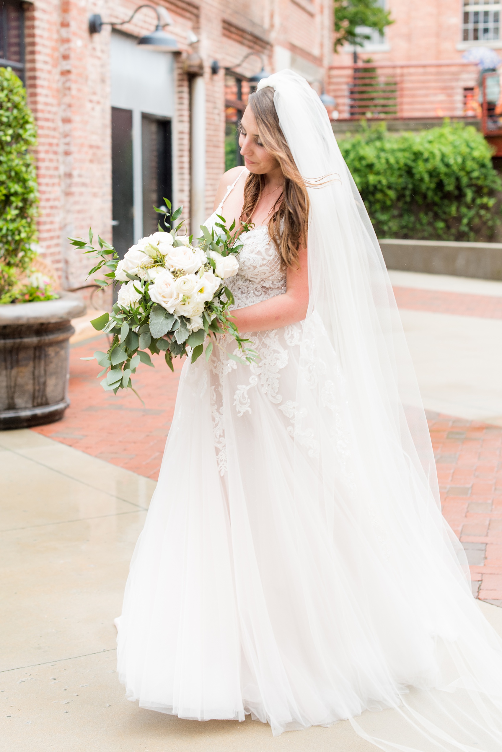 The Rickhouse wedding photos by Mikkel Paige photography in Durham, North Carolina. This urban venue has all the charm of the south for this bride and groom's spring wedding! This detail picture shows the bride in her beaded Essense of Australia gown with a white bouquet and long simple veil. Click through to see the complete post! #mikkelpaige #northcarolina #southernwedding #TheRickhouseDurham #rosegoldandpink #bridalportrait #essenseofaustralia