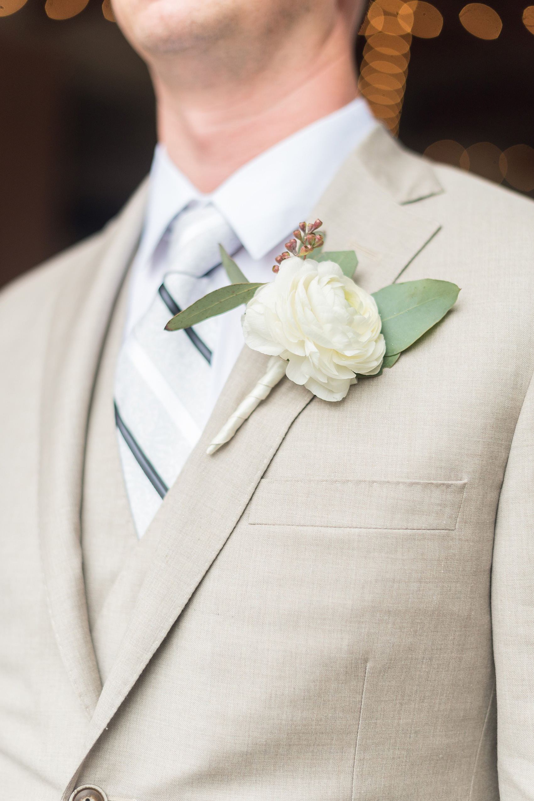 The Rickhouse wedding photos by Mikkel Paige photography in Durham, North Carolina. This urban venue has all the charm of the south for this bride and groom's spring wedding! This detail picture shows the groom's white ranunculus boutonniere with eucalyptus filler. Click through to see the complete post! #mikkelpaige #northcarolina #southernwedding #TheRickhouseDurham #rosegoldandpink #boutonniere #ranunculus