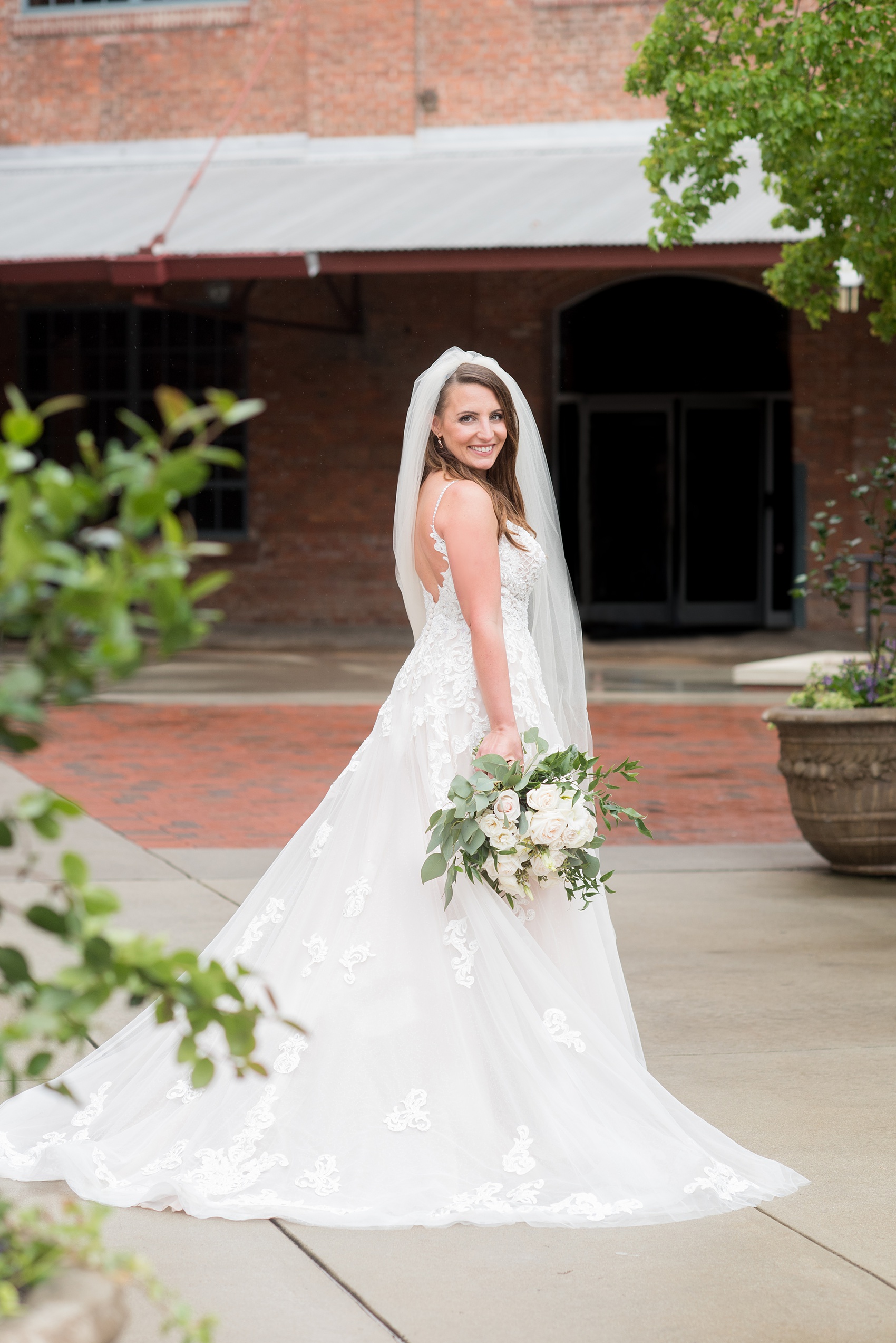 The Rickhouse wedding photos by Mikkel Paige photography in Durham, North Carolina. This urban venue has all the charm of the south for this bride and groom's spring wedding! This detail picture shows the bride in her beaded Essense of Australia gown with a white bouquet and long simple veil. Click through to see the complete post! #mikkelpaige #northcarolina #southernwedding #TheRickhouseDurham #rosegoldandpink #bridalportrait #essenseofaustralia