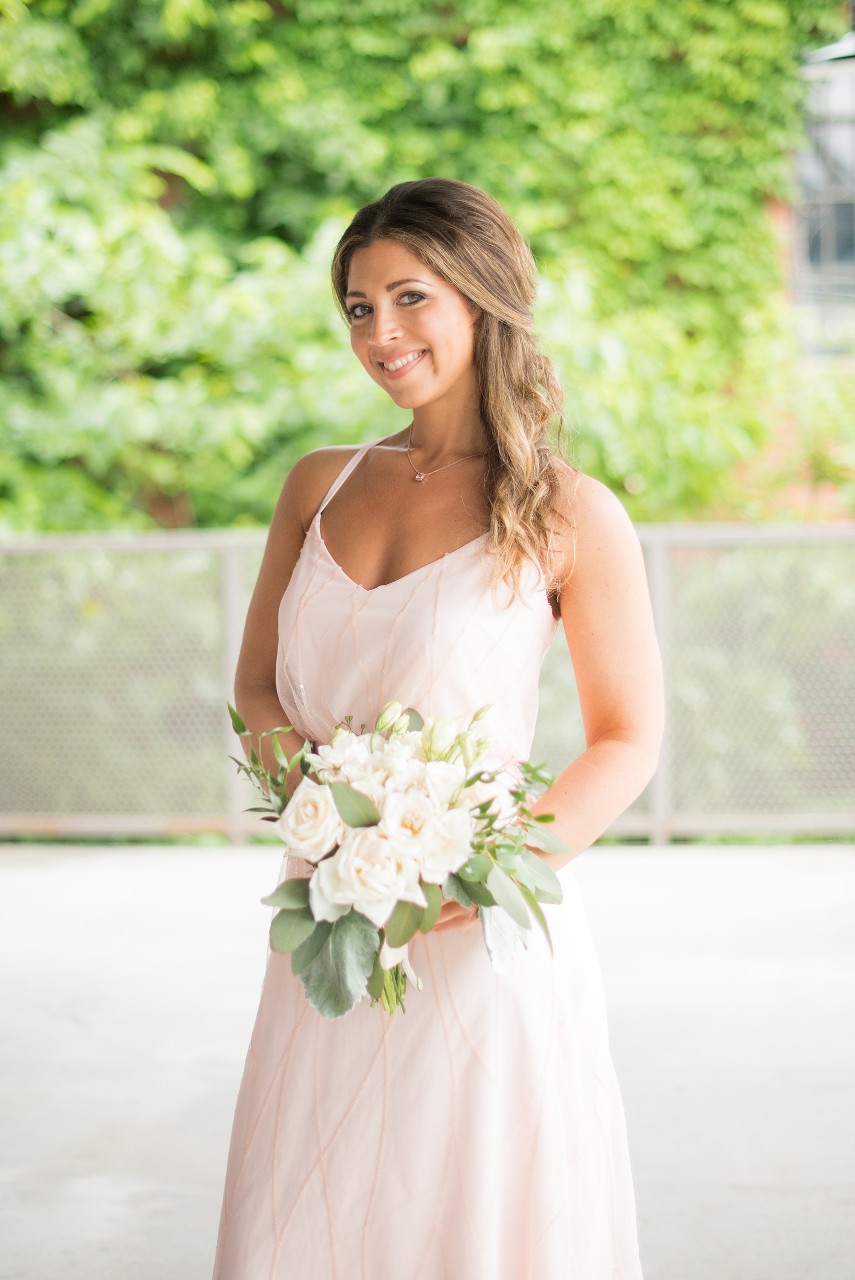 The Rickhouse wedding photos by Mikkel Paige photography in Durham, North Carolina. This urban venue has all the charm of the south for this bride and groom's spring wedding! This picture shows a bridesmaid in a pink gown holding her white bouquet. Click to see more from their day! #mikkelpaige #northcarolina #southernwedding #TheRickhouseDurham #rosegoldandpink #bridalparty #pinkbridesmaids 