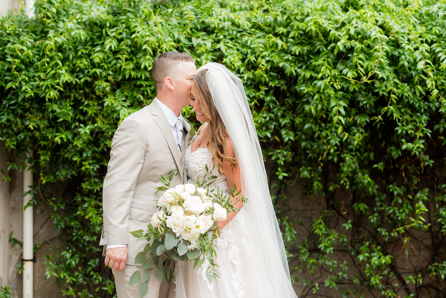 The Rickhouse wedding photos by Mikkel Paige photography in Durham, North Carolina. This urban venue has all the charm of the south for this bride and groom's spring wedding! This picture shows the bride and groom at American Tobacco Campus against a gorgeous wall of green ivy. Click to see more from their day! #mikkelpaige #northcarolina #southernwedding #TheRickhouseDurham #rosegoldandpink #brideandgroom