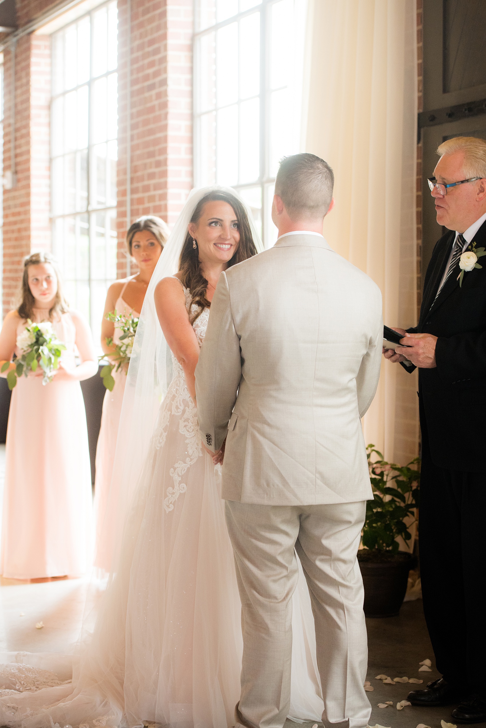 The Rickhouse wedding photos by Mikkel Paige photography in Durham, North Carolina. This urban venue has all the charm of the south for this bride and groom's spring wedding! The bride and groom had an indoor ceremony with white draping. Click to see more from their day! #mikkelpaige #northcarolina #southernwedding #TheRickhouseDurham #rosegoldandpink #weddingceremony #indoorceremony