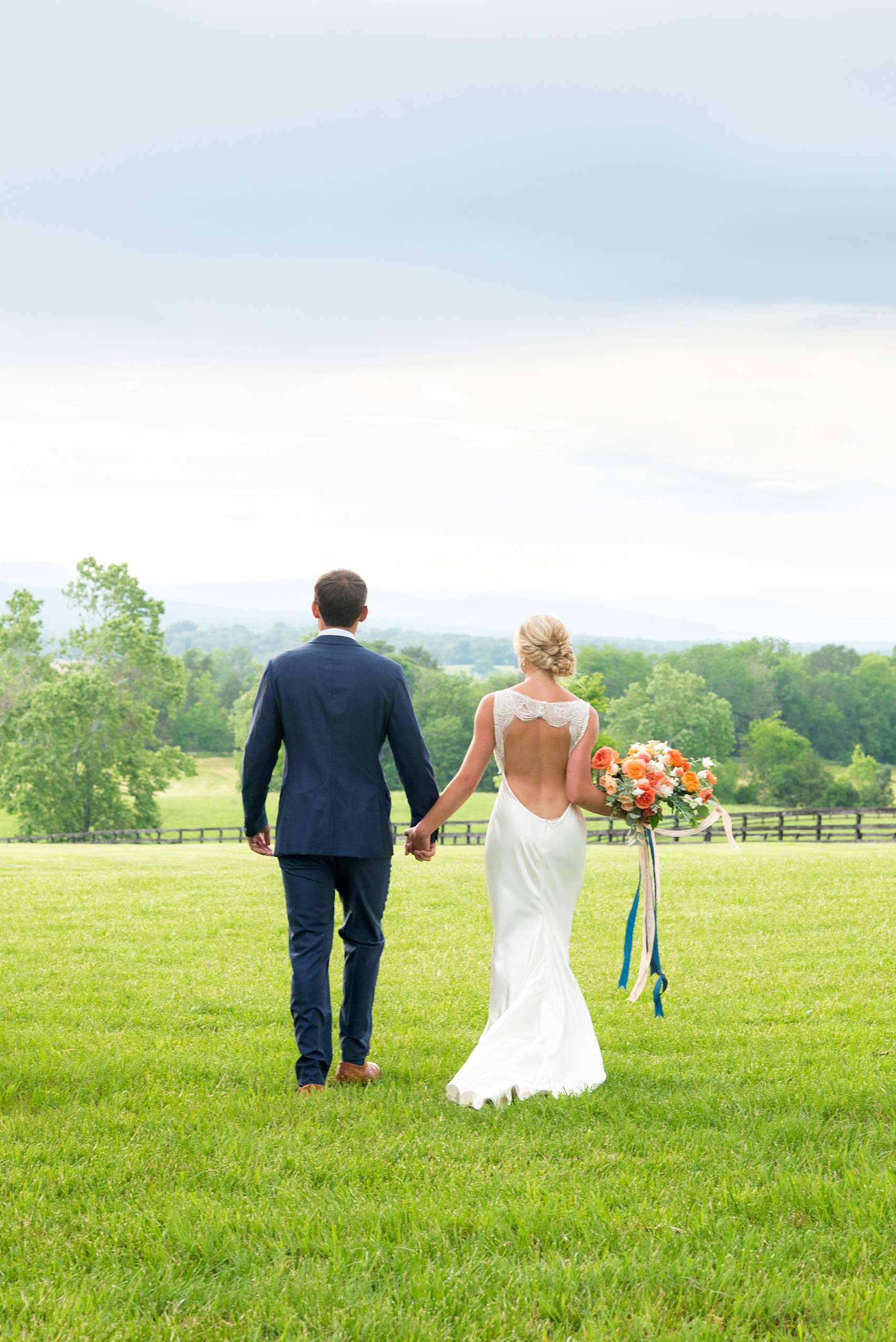 Charlottesville wedding photos by Mikkel Paige Photography. This Virginia venue is perfect for brides and grooms looking for a beautiful farm reception space. It’s green, romantic, and easy to dress up with flowers or keep simple! The bride wore a gorgeous, sexy back cowl neck silk gown by Suzanne Neville and wore her hair in an up-do. The groom wore a navy blue suit and tie and wore a succulent and eucalyptus boutonnière. The bride’s colorful rose, peony and ranunculus bouquet was also dotted with succulents and tied with silk ribbons. Click through for the complete post from this May event at the Lodge at Mount Ida Farm! Planning and design by @vivalevent. #Charlottesville #mountidafarm #lodgeatmountida #CharlottesvilleVA #CharlottesvilleVirginia #Charlottesvillewedding #Charlottesvilleweddingphotographer #mikkelpaige #Vivalevent #brideandgroom #navybluesuit #sexybackweddinggown #backlessweddinggown #suzanneneville #TraditionsbyAnna #WinkHairandMakeup