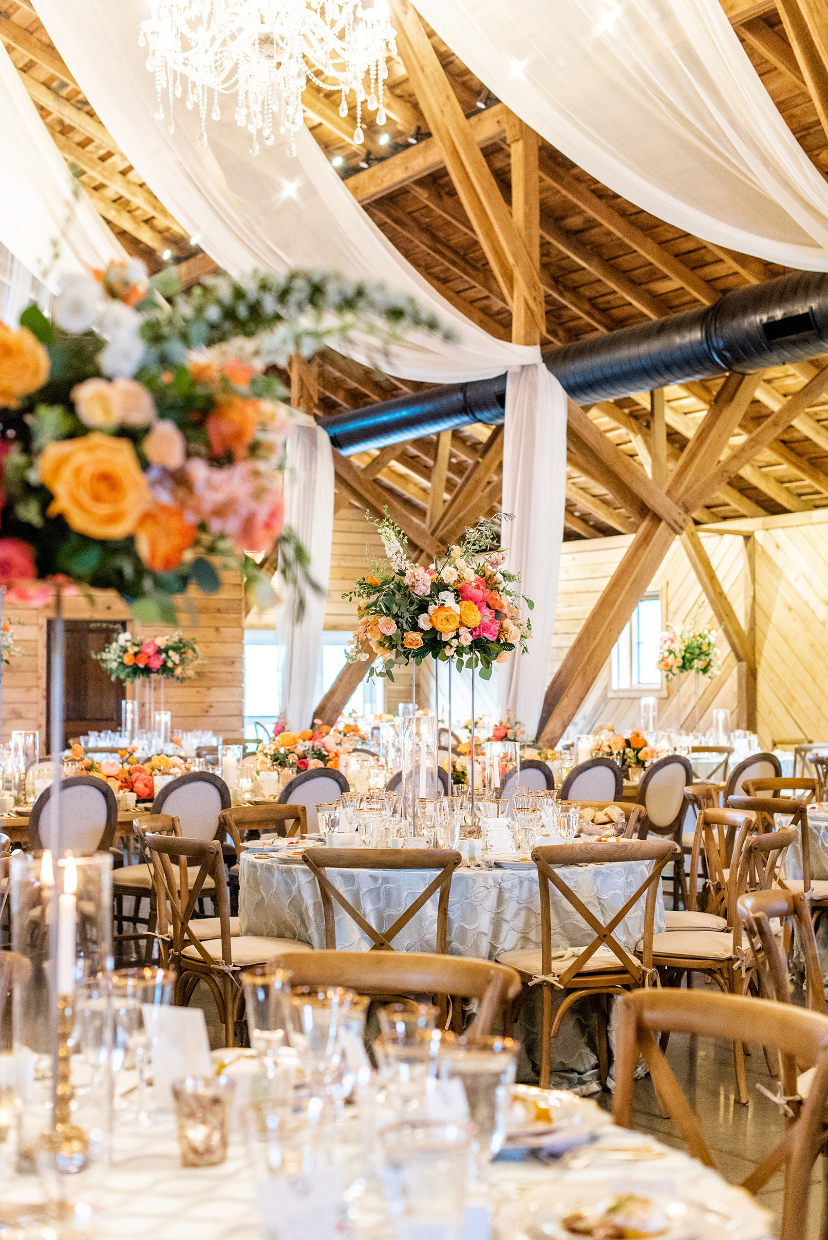 Charlottesville wedding photos by Mikkel Paige Photography. This Virginia venue is perfect for brides and grooms looking for a beautiful farm reception space. It’s green, romantic, and easy to dress up with flowers or keep simple. A rustic and elegant came to life at the reception barn with chandeliers, fabric draping, mixed rectangular farm tables and round luxurious linen-covered round tables inside the venue. Tall and short centerpieces with colorful flowers like garden roses, peonies, ranunculus and succulents completed the tables. Click through for the complete post from this May event at the Lodge at Mount Ida Farm! Planning and design by @vivalevent and flowers by @apassarelli of Meristem Floral. #Charlottesville #mountidafarm #lodgeatmountida #CharlottesvilleVA #CharlottesvilleVirginia #Charlottesvillewedding #Charlottesvilleweddingphotographer #mikkelpaige #MeristemFloral #VivaLEvent