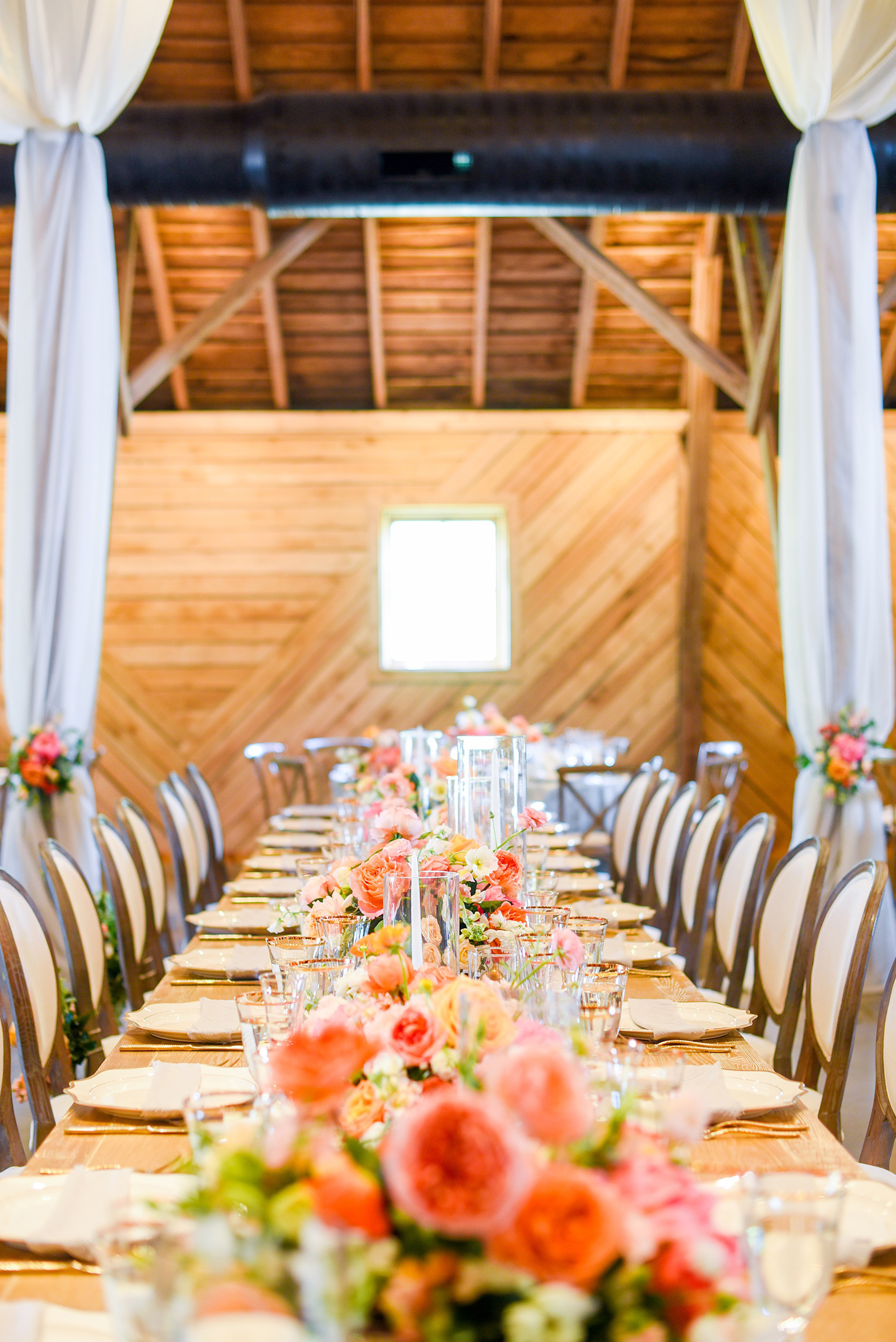 Charlottesville wedding photos by Mikkel Paige Photography. This Virginia venue is perfect for brides and grooms looking for a beautiful farm reception space. It’s green, romantic, and easy to dress up with flowers or keep simple. A rustic and elegant came to life at the reception barn with chandeliers, fabric draping, mixed rectangular farm tables and round luxurious linen-covered round tables inside the venue. Tall and short centerpieces with colorful flowers like garden roses, peonies, ranunculus and succulents completed the tables. Click through for the complete post from this May event at the Lodge at Mount Ida Farm! Planning and design by @vivalevent and flowers by @apassarelli of Meristem Floral. #Charlottesville #mountidafarm #lodgeatmountida #CharlottesvilleVA #CharlottesvilleVirginia #Charlottesvillewedding #Charlottesvilleweddingphotographer #mikkelpaige #MeristemFloral #VivaLEvent