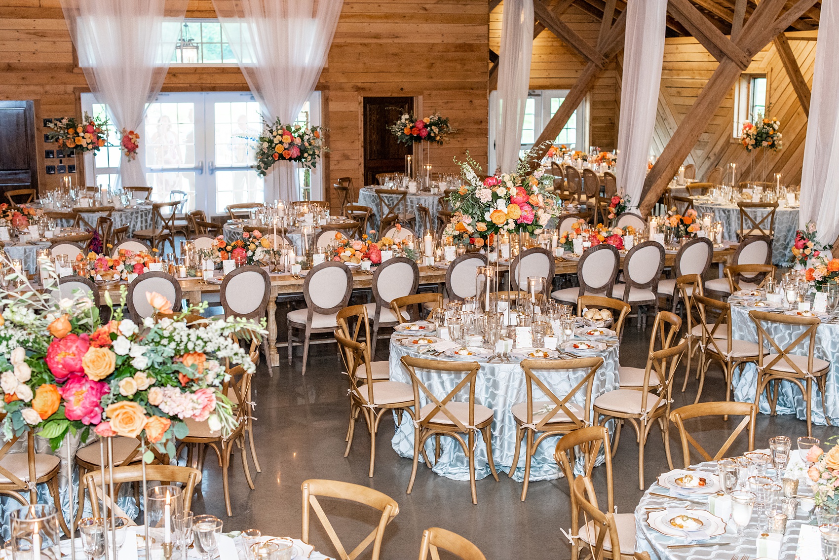 Charlottesville wedding photos by Mikkel Paige Photography. This Virginia venue is perfect for brides and grooms looking for a beautiful farm reception space. It’s green, romantic, and easy to dress up with flowers or keep simple. A rustic and elegant came to life at the reception barn with chandeliers, fabric draping, mixed rectangular farm tables and round luxurious linen-covered round tables inside the venue. Tall and short centerpieces with colorful flowers like garden roses, peonies, ranunculus and succulents completed the tables. Click through for the complete post from this May event at the Lodge at Mount Ida Farm! Planning and design by @vivalevent and flowers by @apassarelli of Meristem Floral. #Charlottesville #mountidafarm #lodgeatmountida #CharlottesvilleVA #CharlottesvilleVirginia #Charlottesvillewedding #Charlottesvilleweddingphotographer #mikkelpaige #MeristemFloral #VivaLEvent