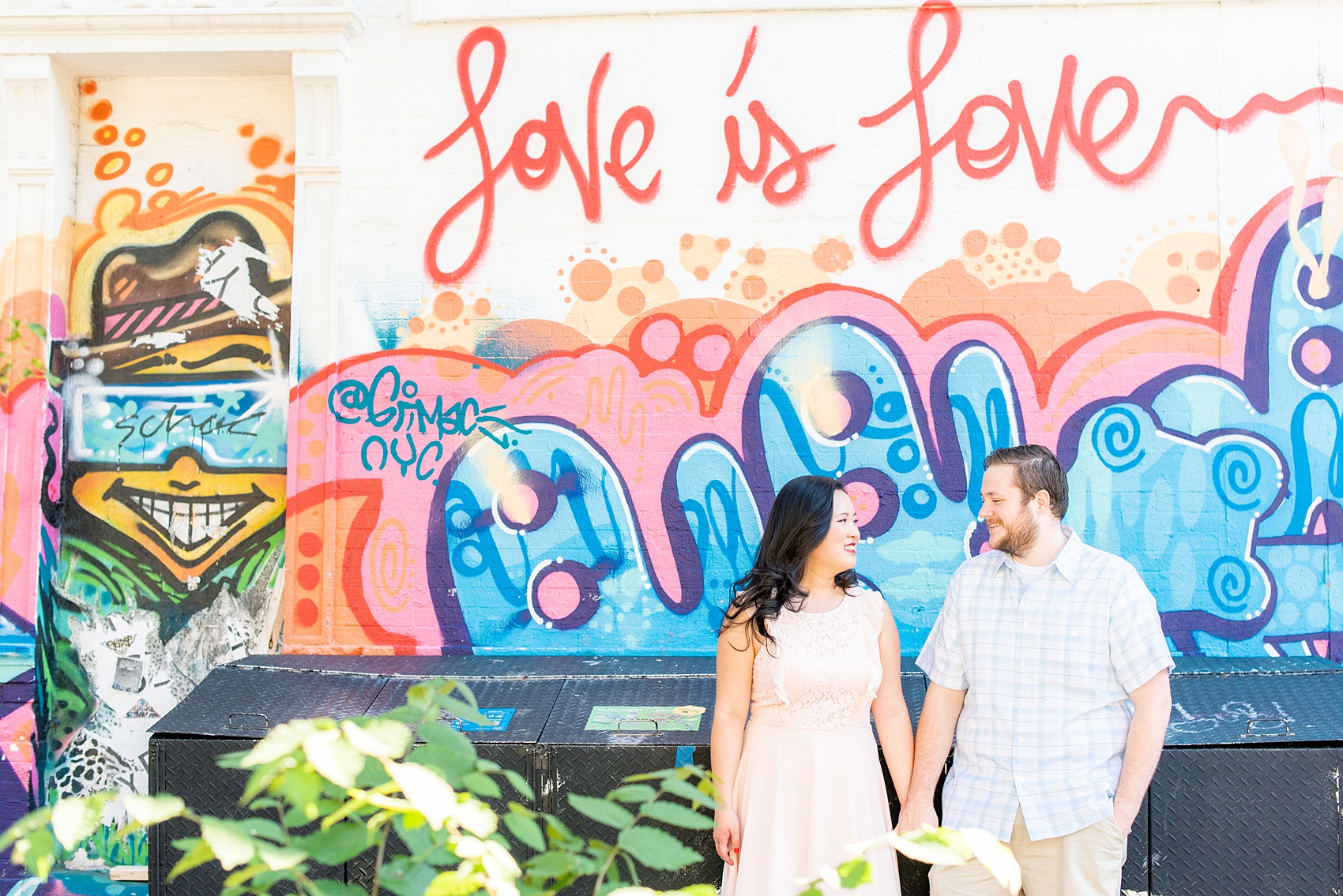 Lower East Side engagement photos in Manhattan by Mikkel Paige Photography. The "Love is Love" graffiti wall and bright mural were perfect for a few images! These creative pictures with an interracial couple in an urban environment in downtown NYC will have you wanting to see more than just this one photo...so be sure to click through to see the entire shoot! #mikkelpaige #EngagementPhotos #engagementshoot #EngagementPictures 