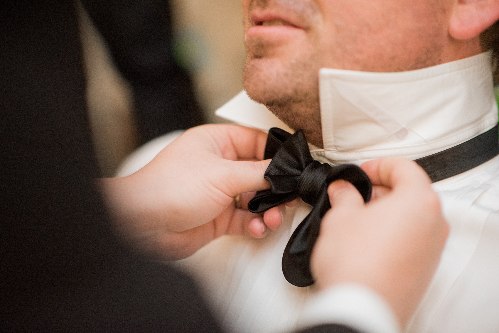 Mikkel Paige Photography pictures of a venue in Durham, North Carolina. The Washington Duke Inn is perfect for a summer wedding! Planning for this beautiful event was by McLean Events. The groom got ready for his wedding day surrounded by his groomsmen in a hotel room onsite, who helped tie his bow tie. Click through for more details about this June wedding with peonies! #MikkelPaige #DurhamWeddings #WashingtonDukeInn #DukeWedding #Duke #McLeanEvents #blueandwhitewedding #groom #bowtie