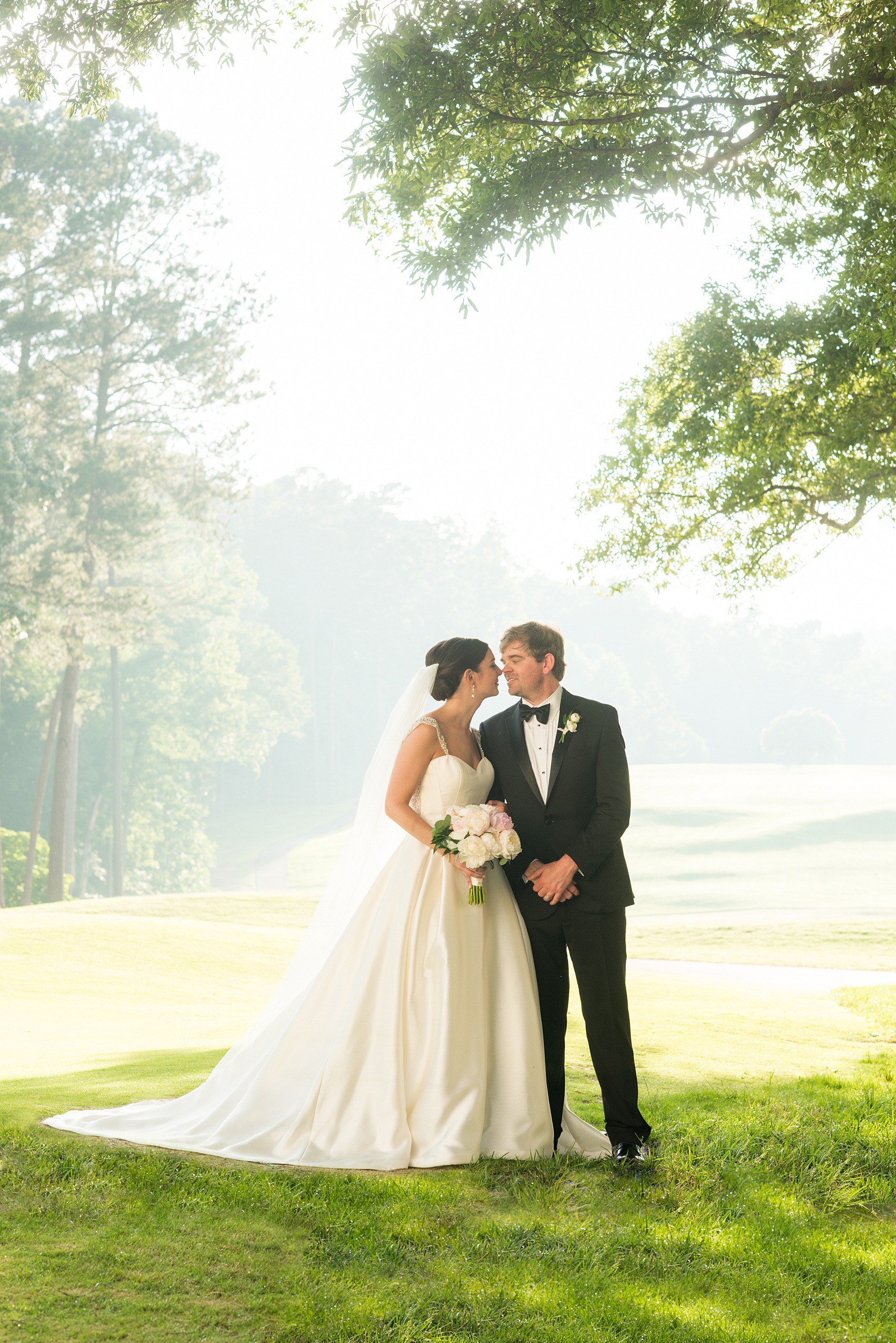 Mikkel Paige Photography pictures of a venue in Durham, North Carolina. The Washington Duke Inn is perfect for a summer wedding! Planning for this beautiful event was by McLean Events. The bride and groom had their pictures taken on the picturesque golf course during golden hour. Click through for more details about this June wedding with peonies! #MikkelPaige #DurhamWeddings #WashingtonDukeInn #DukeWedding #Duke #McLeanEvents #blueandwhitewedding #golfcoursewedding #golfcoursephotos #brideandgroom