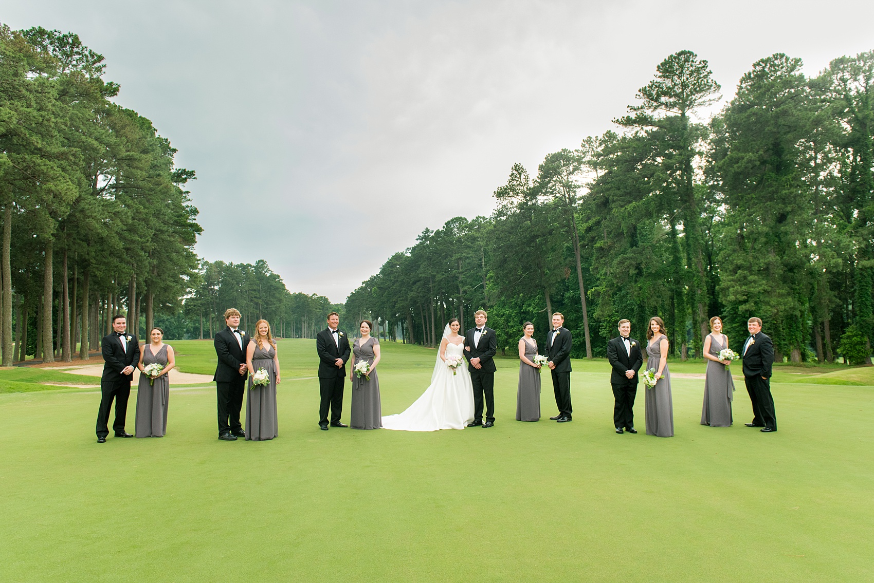 Mikkel Paige Photography pictures of a venue in Durham, North Carolina. The Washington Duke Inn is perfect for a summer wedding! Planning for this beautiful event was by McLean Events. The bride, groom and bridal party had their unique pictures taken on the picturesque golf course. The bridesmaids wore grey chiffon gowns and groomsmen in classic black tuxedos. Hair and Makeup was done by Wink. Click through for more details about this June wedding with peonies! #MikkelPaige #DurhamWeddings #WashingtonDukeInn #DukeWedding #Duke #McLeanEvents #blueandwhitewedding #golfcoursewedding #golfcoursephotos #brideandgroom #bridalparty #weddingparty #greybridesmaids #peonybouquet