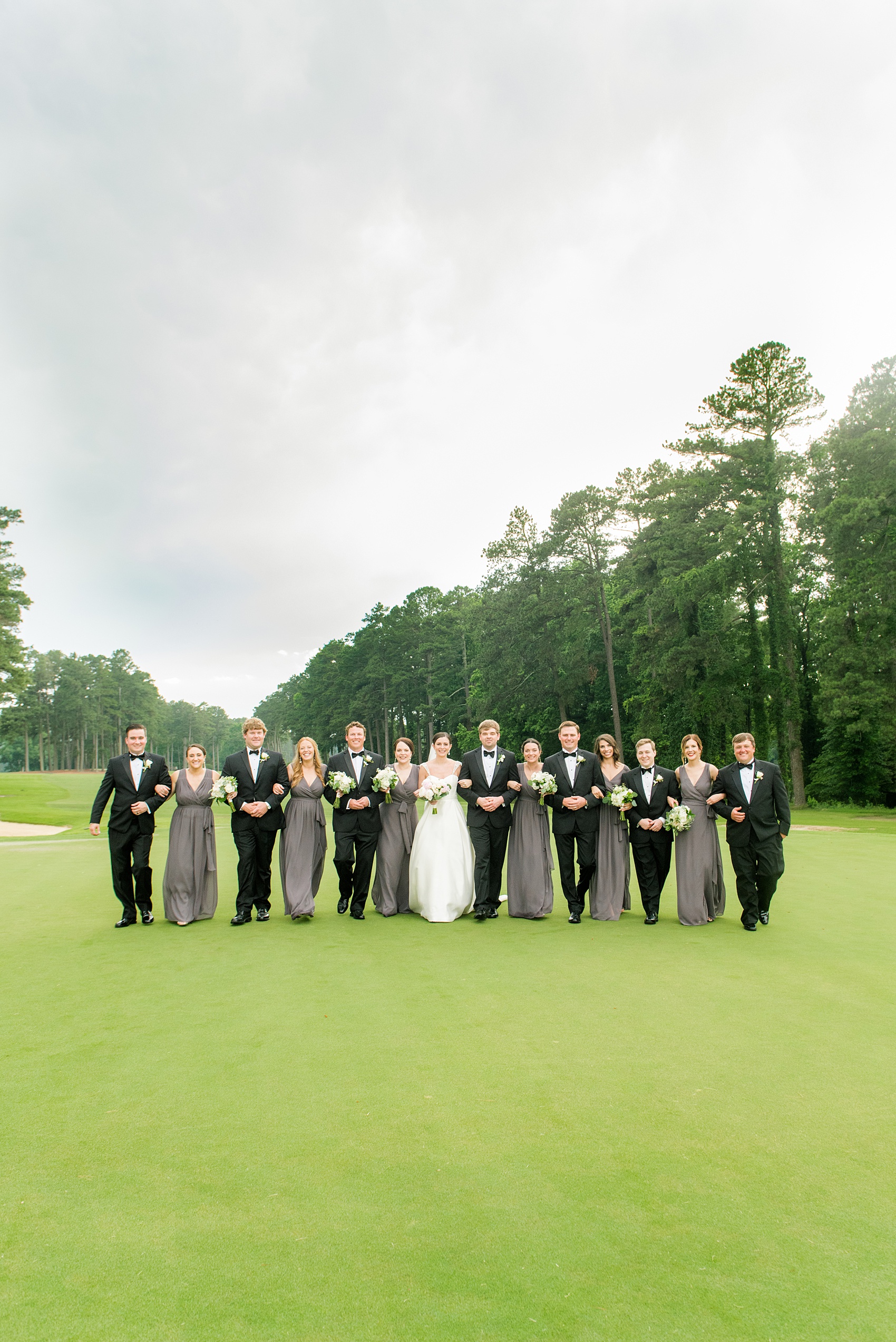 Mikkel Paige Photography pictures of a venue in Durham, North Carolina. The Washington Duke Inn is perfect for a summer wedding! Planning for this beautiful event was by McLean Events. The bride, groom and bridal party had their pictures taken on the picturesque golf course. The bridesmaids wore grey chiffon gowns and groomsmen in classic black tuxedos. Hair and Makeup was done by Wink. Click through for more details about this June wedding with peonies! #MikkelPaige #DurhamWeddings #WashingtonDukeInn #DukeWedding #Duke #McLeanEvents #blueandwhitewedding #golfcoursewedding #golfcoursephotos #brideandgroom #bridalparty #weddingparty #greybridesmaids #peonybouquet