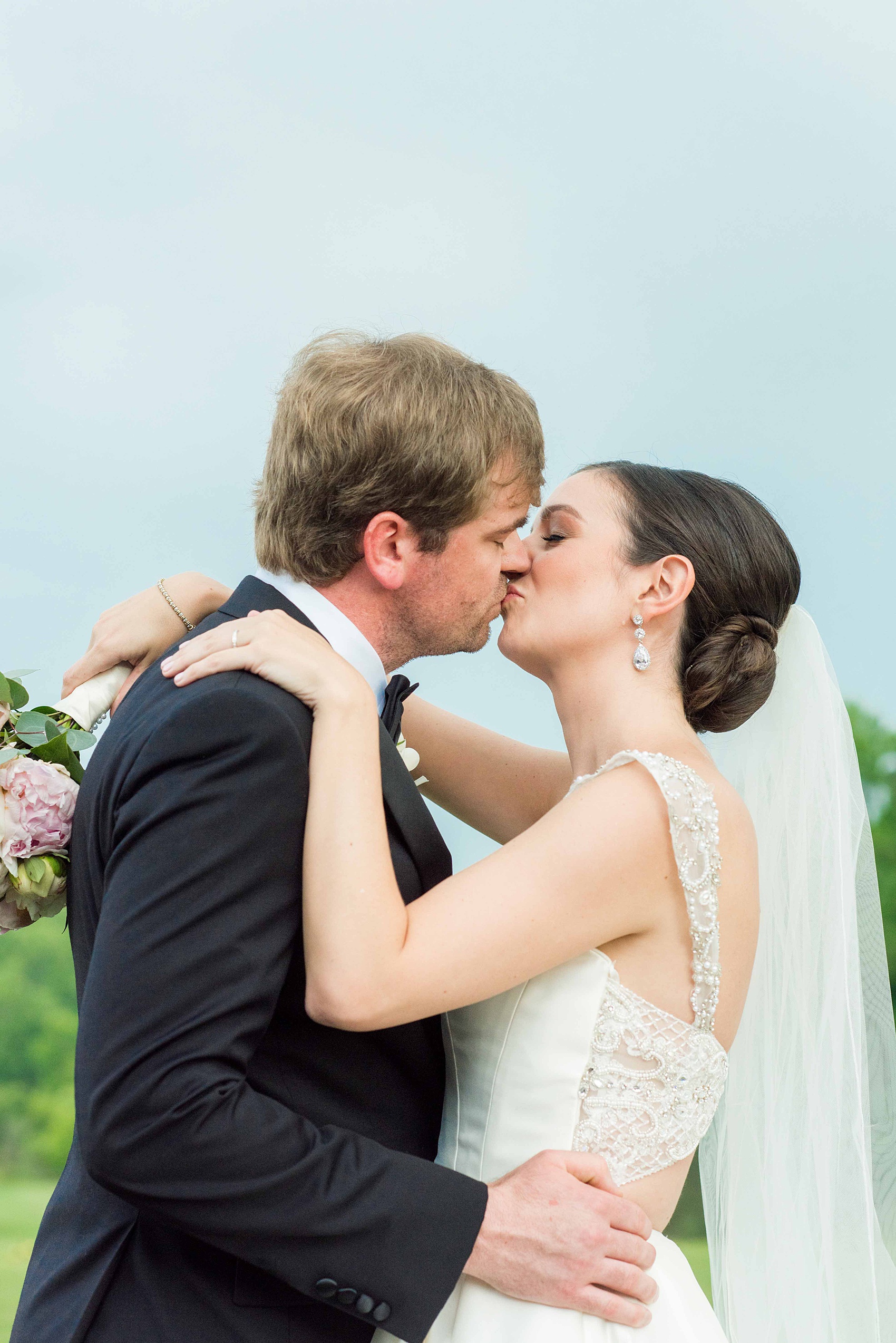 Mikkel Paige Photography pictures of a venue in Durham, North Carolina. The Washington Duke Inn is perfect for a summer wedding! Planning for this beautiful event was by McLean Events. The bride and groom had their pictures taken on the picturesque golf course during golden hour. The back of the bride's gown was incredible and had intricate beading behind her white veil. Hair and Makeup was done by Wink. Click through for more details about this June wedding with peonies! #MikkelPaige #DurhamWeddings #WashingtonDukeInn #DukeWedding #Duke #McLeanEvents #blueandwhitewedding #golfcoursewedding #golfcoursephotos #brideandgroom #winkhairandmakeup