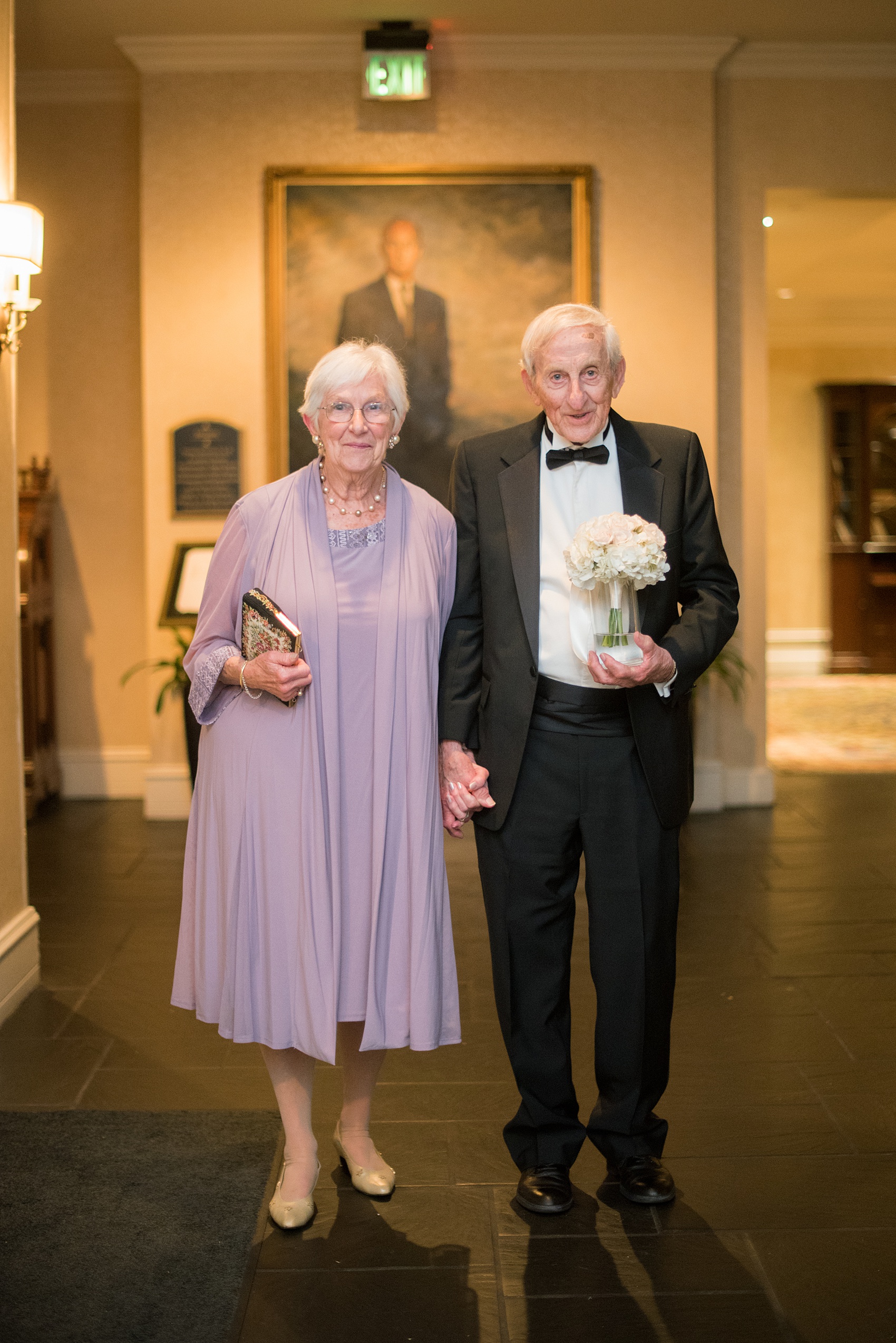 Mikkel Paige Photography pictures of a venue in Durham, North Carolina. The Washington Duke Inn is perfect for a summer wedding! Planning for this beautiful event was by McLean Events. This picture shows the longest married guests, over fifty years, leaving the wedding. Click through for more details about this June wedding with peonies! #MikkelPaige #DurhamWeddings #WashingtonDukeInn #DukeWedding #Duke #McLeanEvents #blueandwhitewedding #golfcoursewedding #bluereception #indoorreception #weddingguests