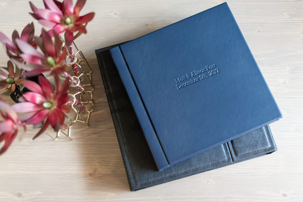 Navy blue leather fine art wedding album from Mikkel Paige Photography, with photos from a snowy winter wedding at The Carolina Inn, in North Carolina. This beatiful, historic venue in Chapel Hill is perfect for outdoor and indoor events no matter if it's spring, summer or fall too. Click through to see more pictures of this couples gorgeous family heirloom keepsakes! #mikkelpaige #carolinainnweddingphotos #carolinainn #leatheralbum #weddingalbum #chapelhill