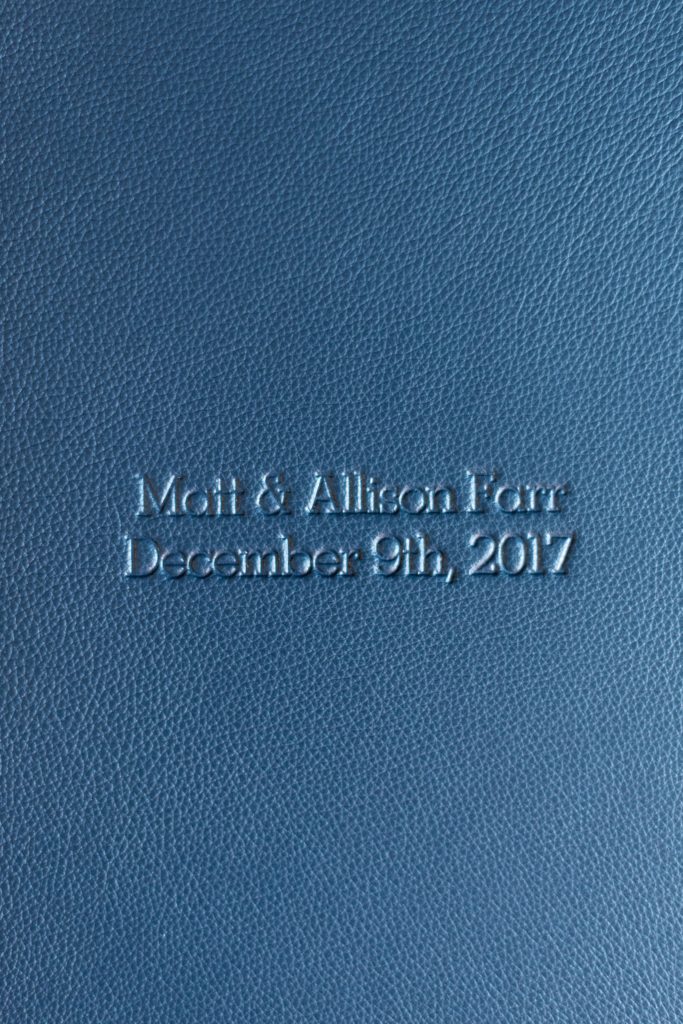 Navy blue leather fine art wedding album from Mikkel Paige Photography, with photos from a snowy winter wedding at The Carolina Inn, in North Carolina. This beatiful, historic venue in Chapel Hill is perfect for outdoor and indoor events no matter if it's spring, summer or fall too. Click through to see more pictures of this couples gorgeous family heirloom keepsakes! #mikkelpaige #carolinainnweddingphotos #carolinainn #leatheralbum #weddingalbum #chapelhill