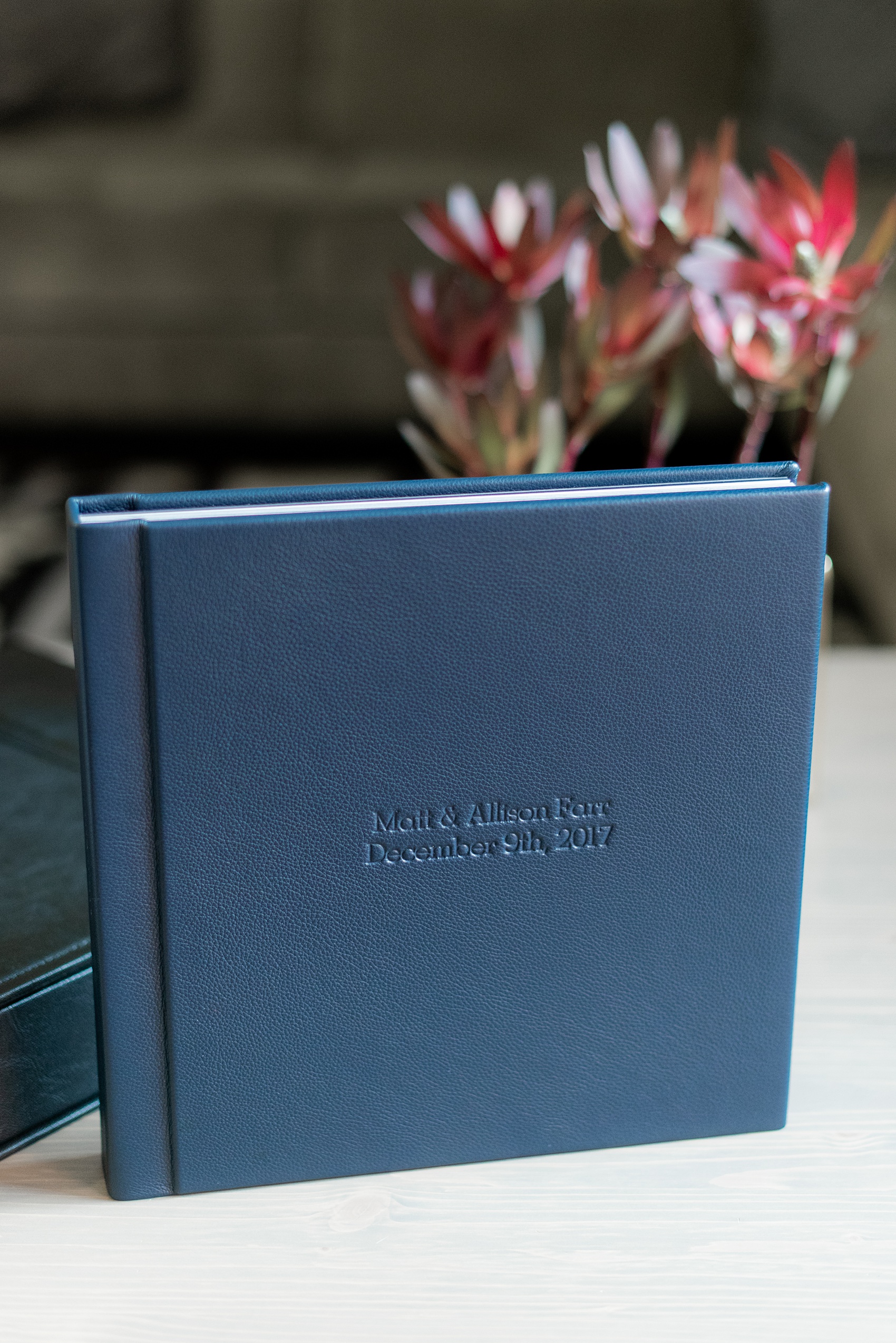 Navy blue leather fine art wedding album from Mikkel Paige Photography, with photos from a snowy winter wedding at The Carolina Inn, in North Carolina. This beatiful, historic venue in Chapel Hill is perfect for outdoor and indoor events no matter if it's spring, summer or fall too. Click through to see more pictures of this couples gorgeous family heirloom keepsakes! #mikkelpaige #carolinainnweddingphotos #carolinainn #leatheralbum #weddingalbum #chapelhill