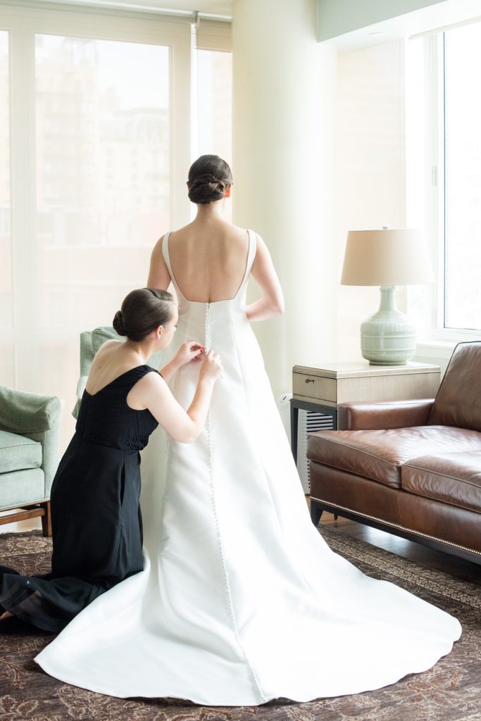 Manhattan Central Park wedding photos by Mikkel Paige Photography at Loeb Boathouse venue. These summer ceremony and reception pictures show a timeless couple having fun at their colorful day with guests who traveled in from abroad. The bride prepared for the day with her bridesmaids as her sister and Maid of Honor buttoned her Sottero and Midgley gown. Click through for the complete post! #CentralParkWeddingVenues #NYCweddingphotographer #NYCwedding #gettingready #bridalpictures #WeddingGown