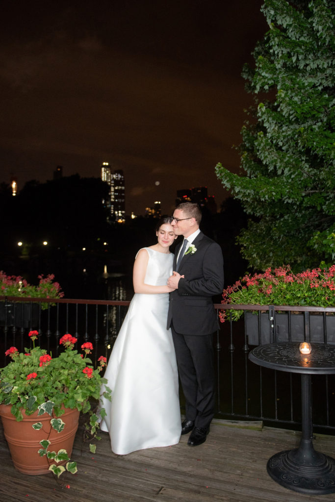 Manhattan Central Park wedding photos by Mikkel Paige Photography at Loeb Boathouse venue. The reception was by the lake and Bethesda Terrace for a June celebration. The bride and groom shared an emotional moment on the patio during dancing with the NYC skyline in the background at night. Click through for the complete post! #CentralParkWeddingVenues #NYCwedding #SummerWedding #weddingreception #brideandgroom #NYCskyline #brideandgroomnightphotos #weddingnightphotos