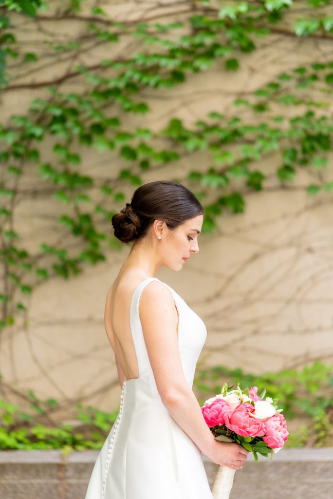 Manhattan Central Park wedding photos by Mikkel Paige Photography at Loeb Boathouse venue. These reception pictures show a timeless couple having fun at their colorful day in this iconic NYC landmark. The bride held a pink and white peonies bouquet for their June celebration and wore a boat-neck gown with buttons down the back. Click through for the complete post! #CentralParkWeddingVenues #NYCweddingphotographer #NYCwedding #SummerWedding #CentralParkPhotos #NYCbride #SotteroandMidgley