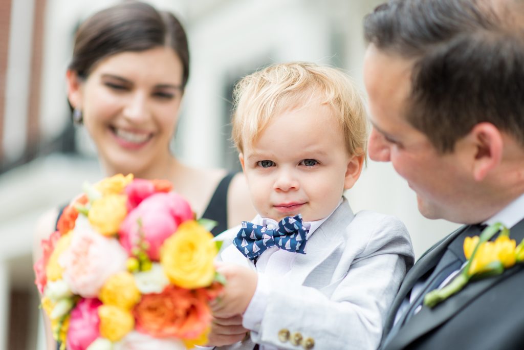 Manhattan Central Park wedding photos by Mikkel Paige Photography at Loeb Boathouse venue. These reception pictures show a timeless couple having fun at their colorful day in this iconic NYC landmark. Their toddler nephew was their ring bearer and wore a blue seersucker suit and bow tie. Click through for the complete post! #CentralParkWeddingVenues #NYCweddingphotographer #SummerWedding #CentralParkPhotos #NYCwedding #ring bearer