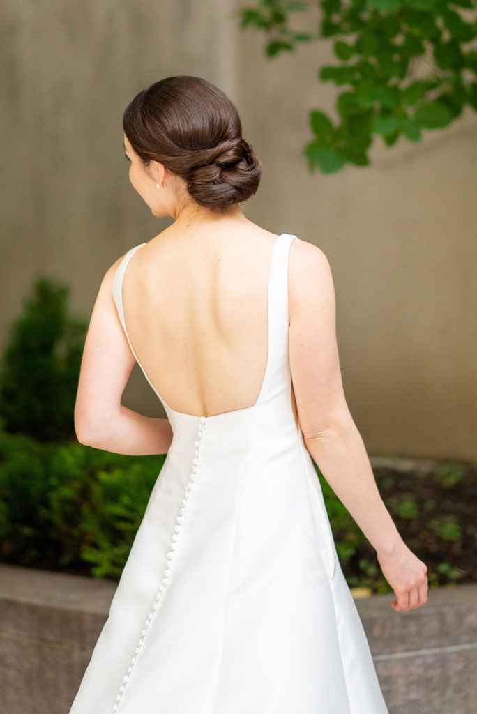 Manhattan Central Park wedding photos by Mikkel Paige Photography at Loeb Boathouse venue. These reception pictures show a couple having fun at their colorful day in this iconic NYC landmark. The bride wore a boat-neck gown with buttons down the low back and had a neat, swept back, timeless bridal hair up-do. Click through for the complete post! #CentralParkWeddingVenues #NYCweddingphotographer #NYCwedding #SummerWedding #CentralParkPhotos #NYCbride #SotteroandMidgley #updo #bridalhair