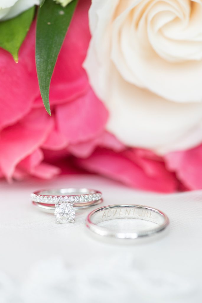 Manhattan Central Park wedding photos by Mikkel Paige Photography at Loeb Boathouse venue. These summer ceremony and reception pictures show a timeless couple having fun at their colorful day with family and friends who traveled in from abroad. This detail image shows their white gold rings and the engraving "Adventure" on the groom's band, symbolic of their love of travel. Click through for more details from their day! #CentralParkWeddingVenues #weddingdetails #weddingrings #ringengraving