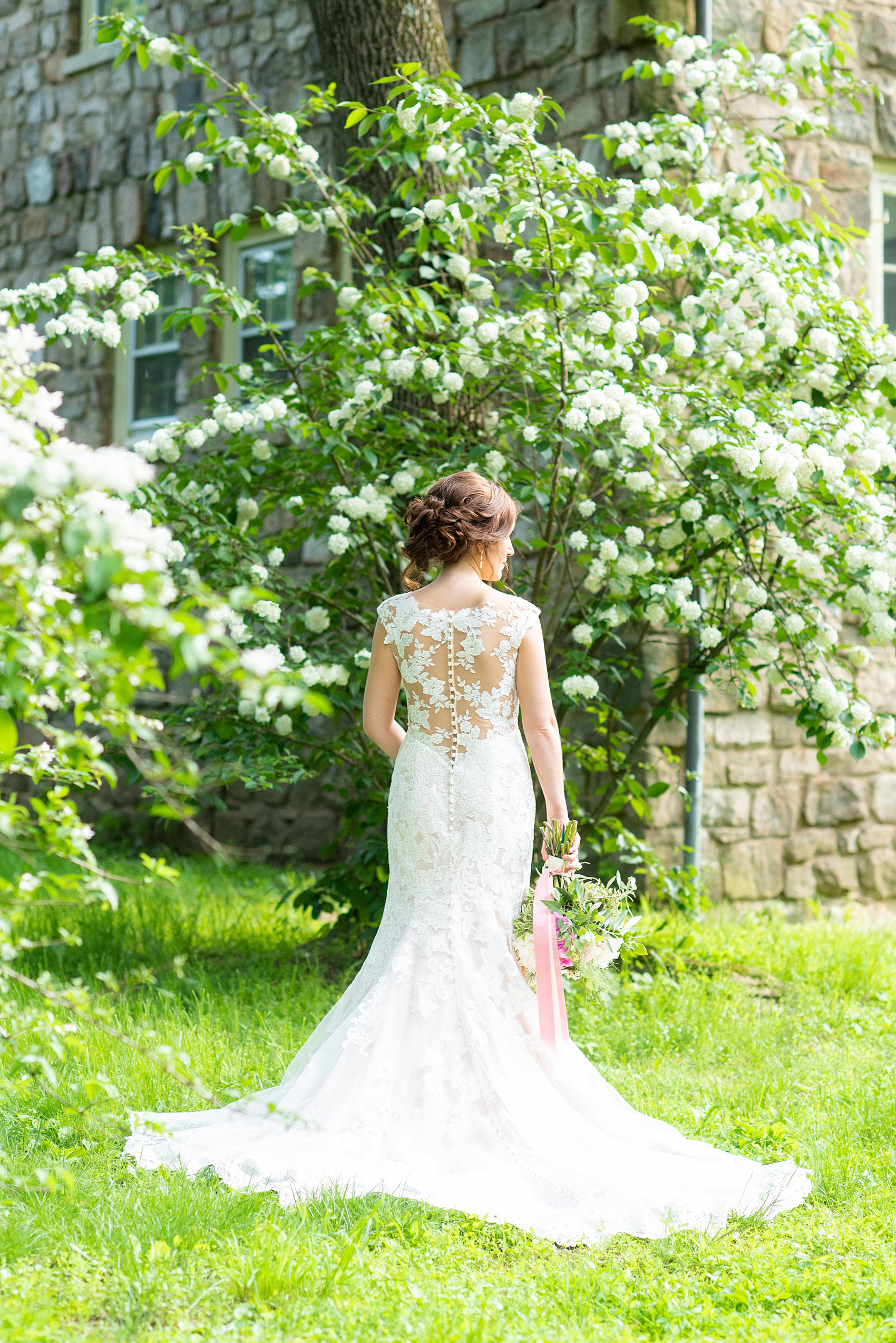 A summer wedding at Olde Mill Inn, NJ. Photos by Mikkel Paige Photography for an event with pink and blue details. The bridal portraits were taken at Cross Estate Gardens, just down the road from this New Jersey Venue. The beautiful pictures of the bride show her lace Allure Bridal gown with appliqué and button detail. Click through for their complete wedding recap! #OldeMillInn #NJwedding #NJweddingphotographer #mikkelpaige #NewJerseyWeddingVenue #NewJerseyWedding #CrossEstateGardens #bridalportraits #bride #herecomesthebride #AllureBridal #laceweddinggown